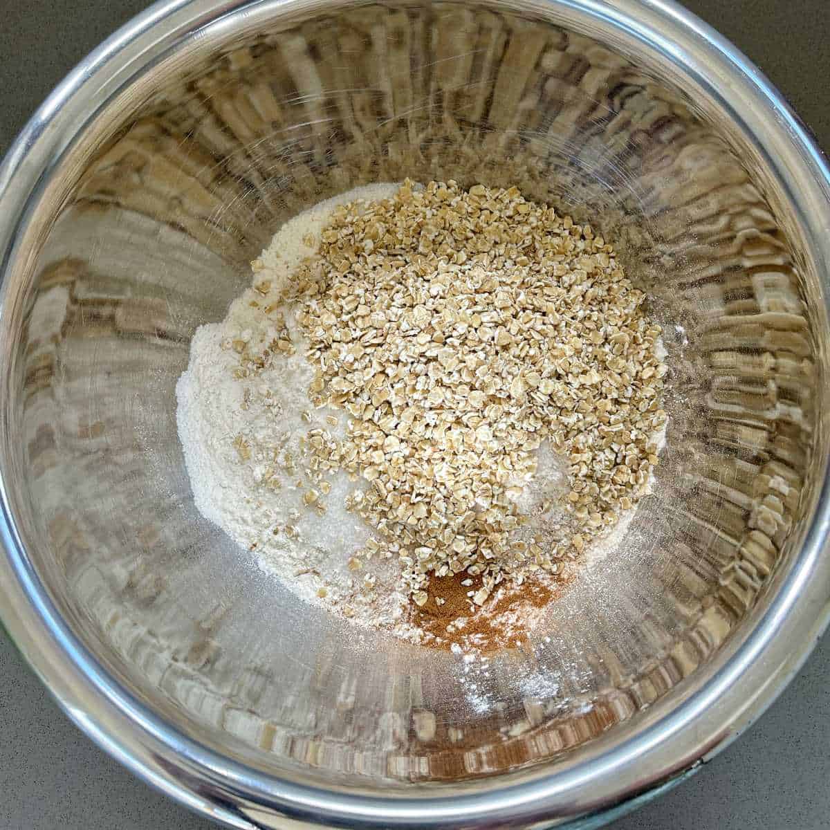 Crumble mix in a glass bowl on a grey bench
