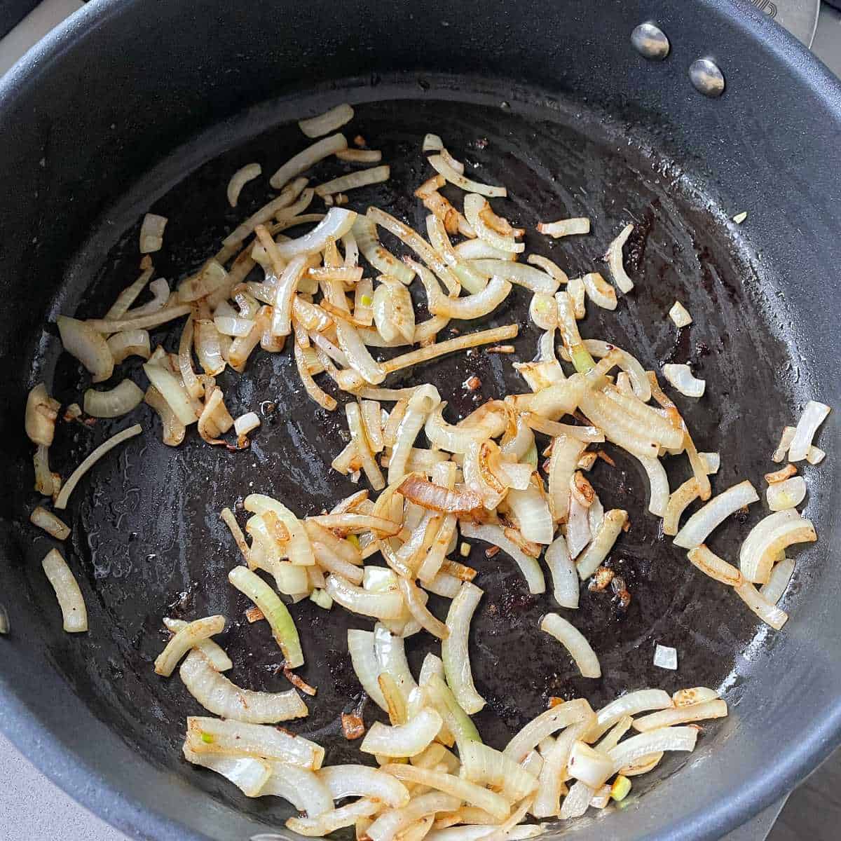 Onions sliced frying in a pan