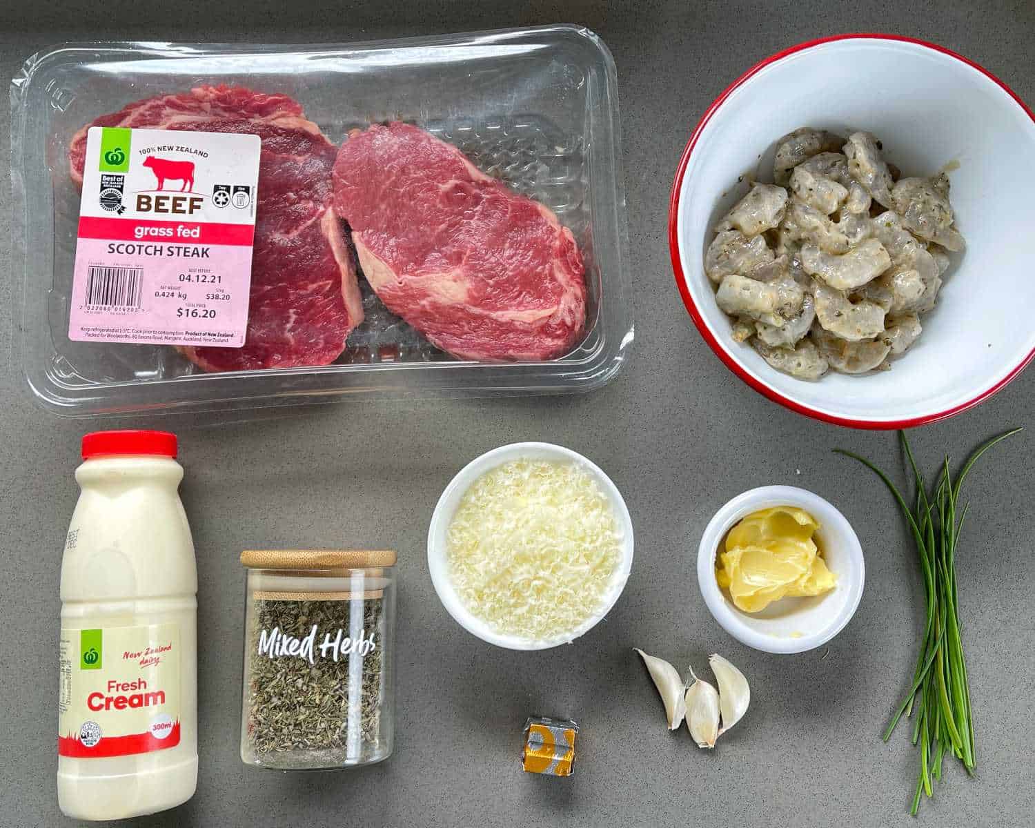 Ingredients for steak and creamy garlic pawns sitting on a grey bench