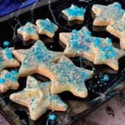 Star shortbread cookies on a black tray.