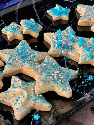 Star shortbread cookies on a black tray.