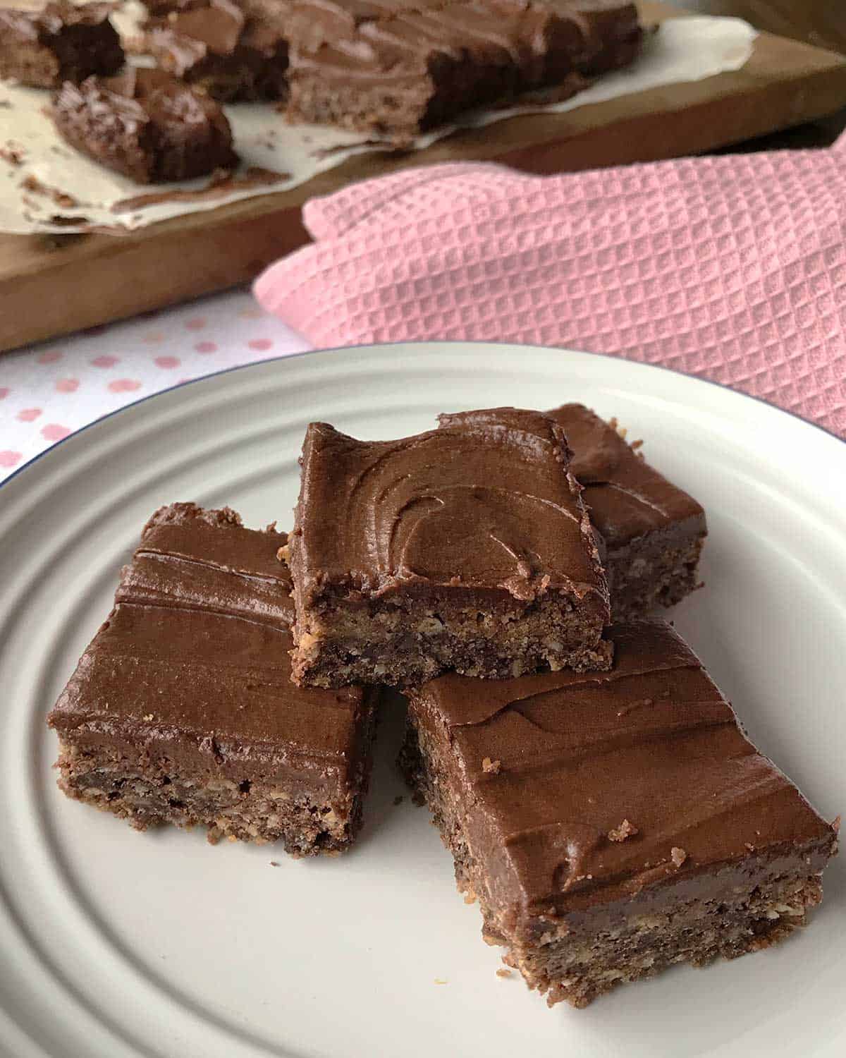 Three pieces of chocolate weetbix slice on a white plate.