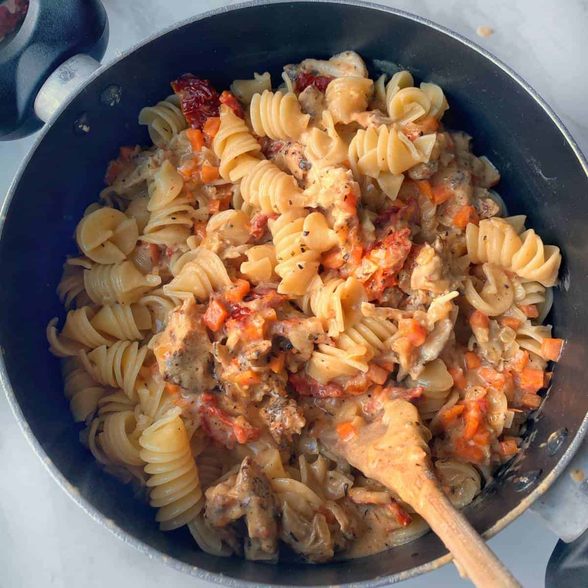 Cooked cheesy chicken pasta in a fry pan
