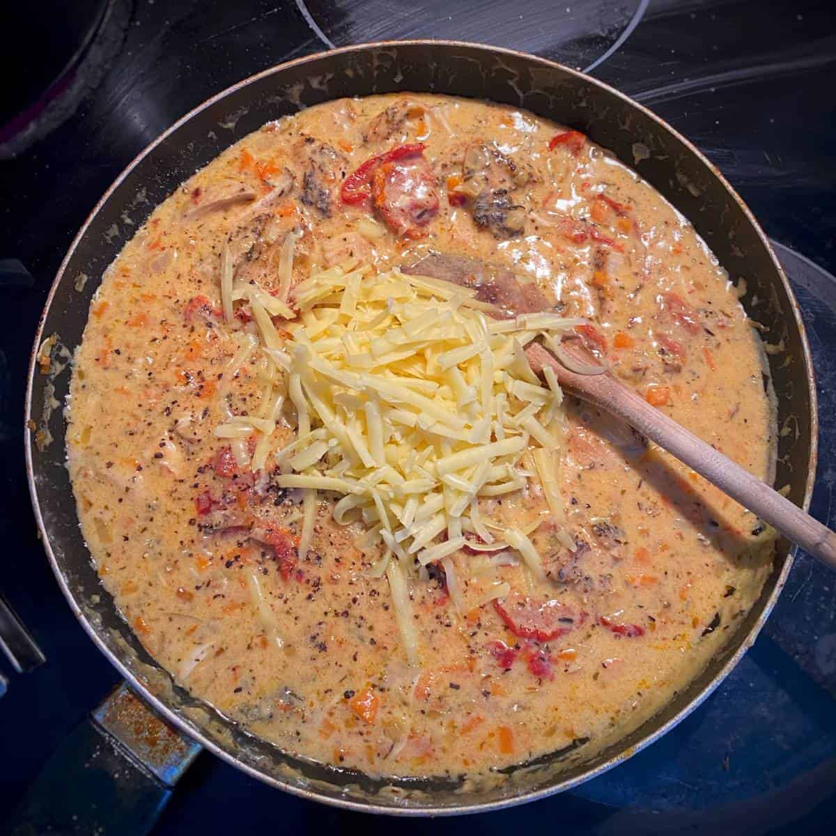 Cheesy chicken pasta cooking in a frypan