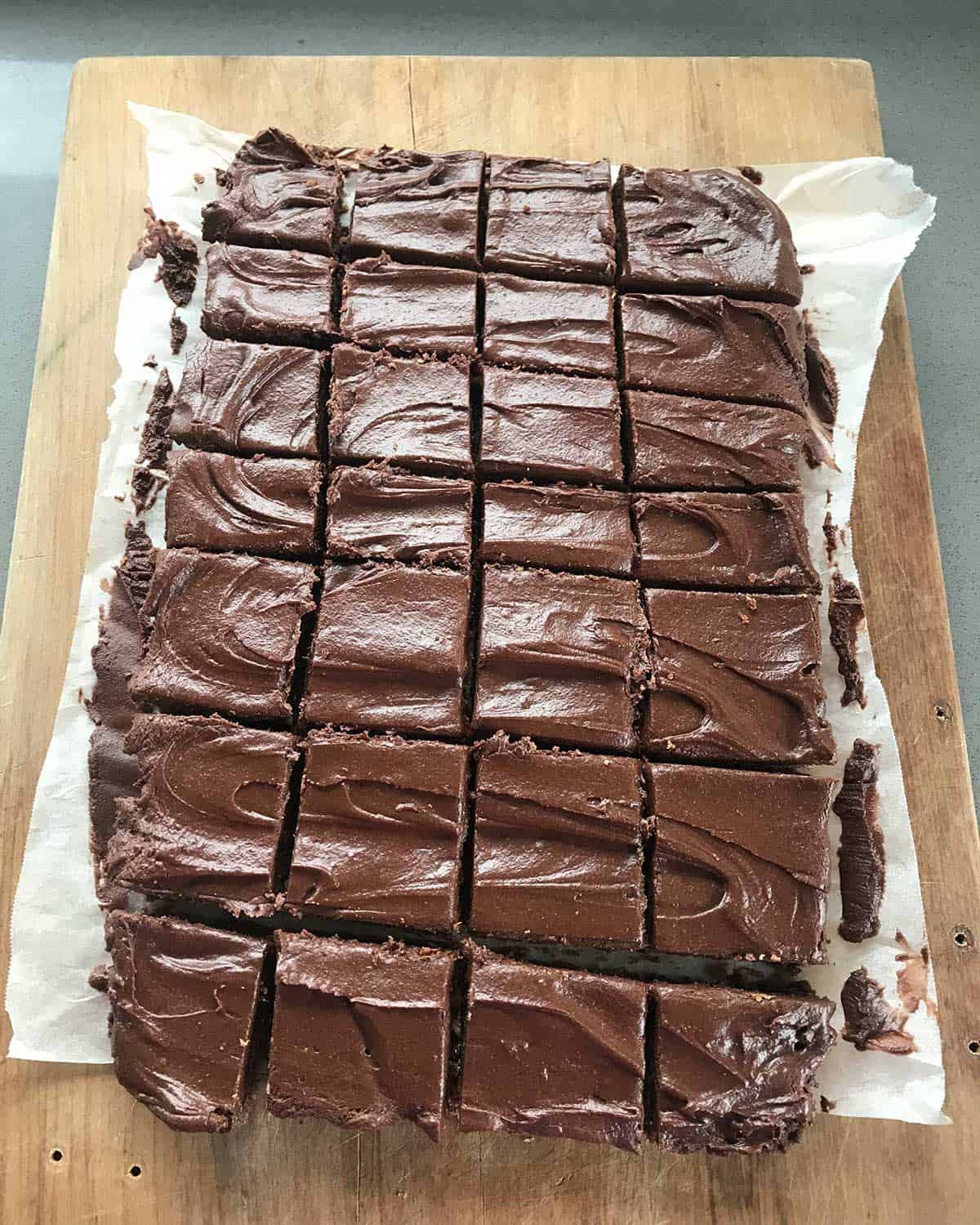 Slices of Chocolate Weetbix slice on a wooden chopping board.