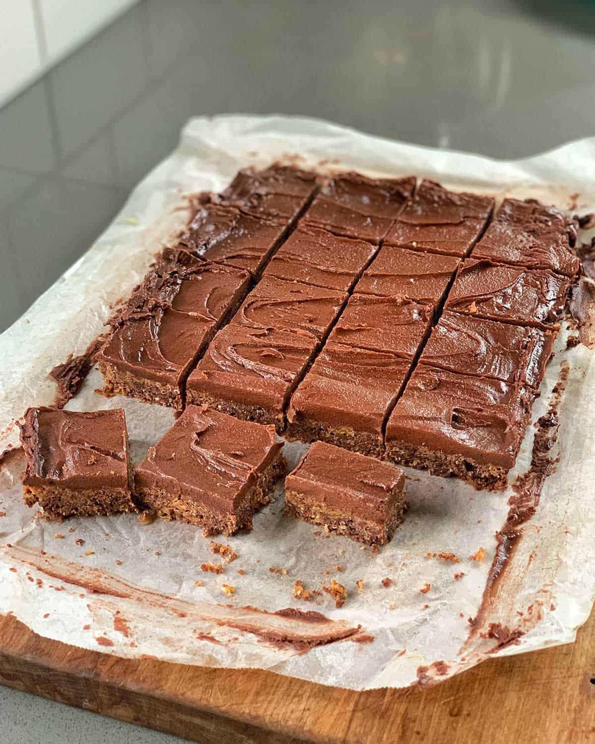 A chopping board with pieces of Chocolate Weetbix Slice on it.