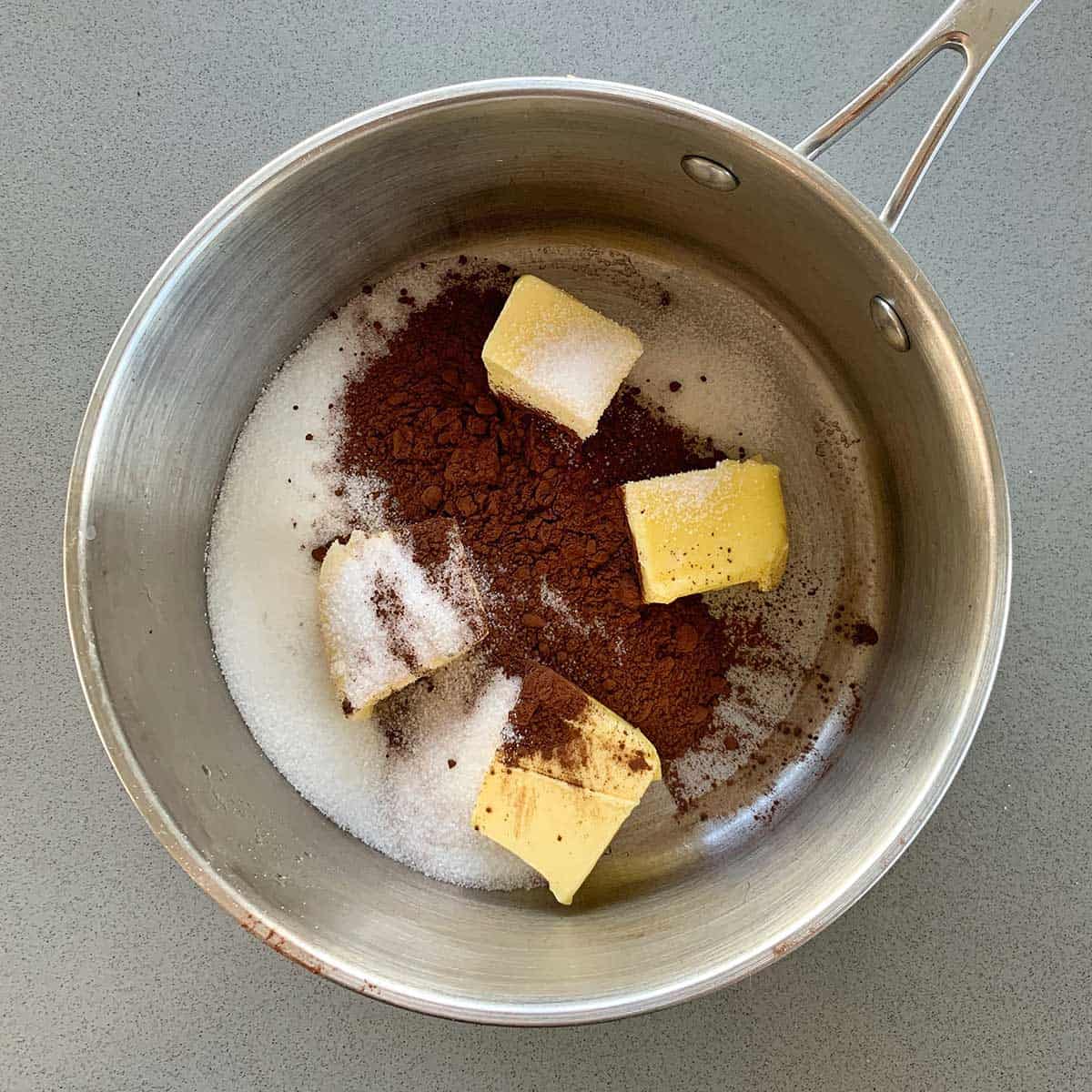Butter, cocoa and sugar in the bottom of a saucepan.