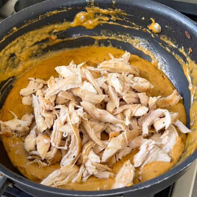 The butter chicken mixture cooking in a frypan