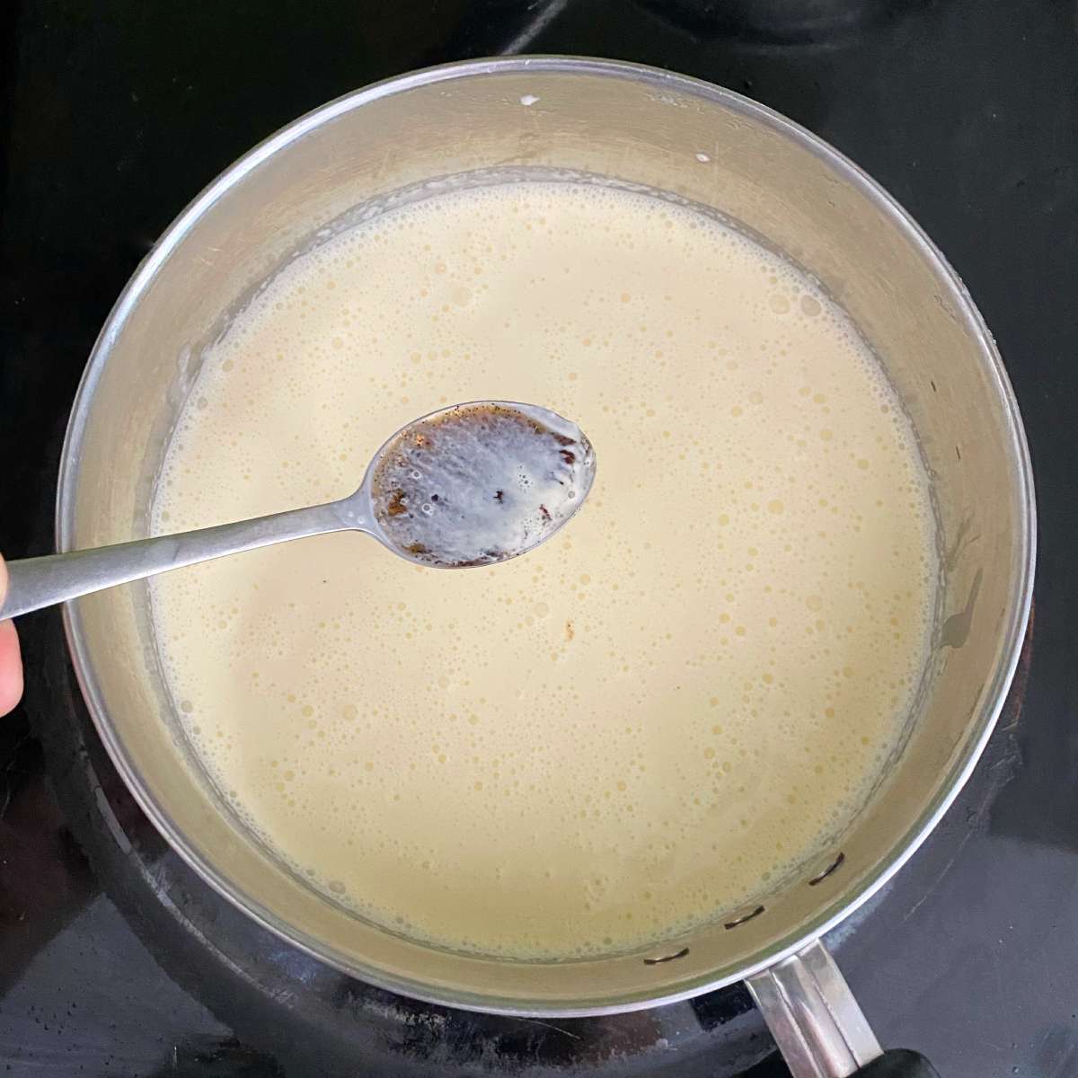 The creme brulee mixture being heated in a pot over a medium heat