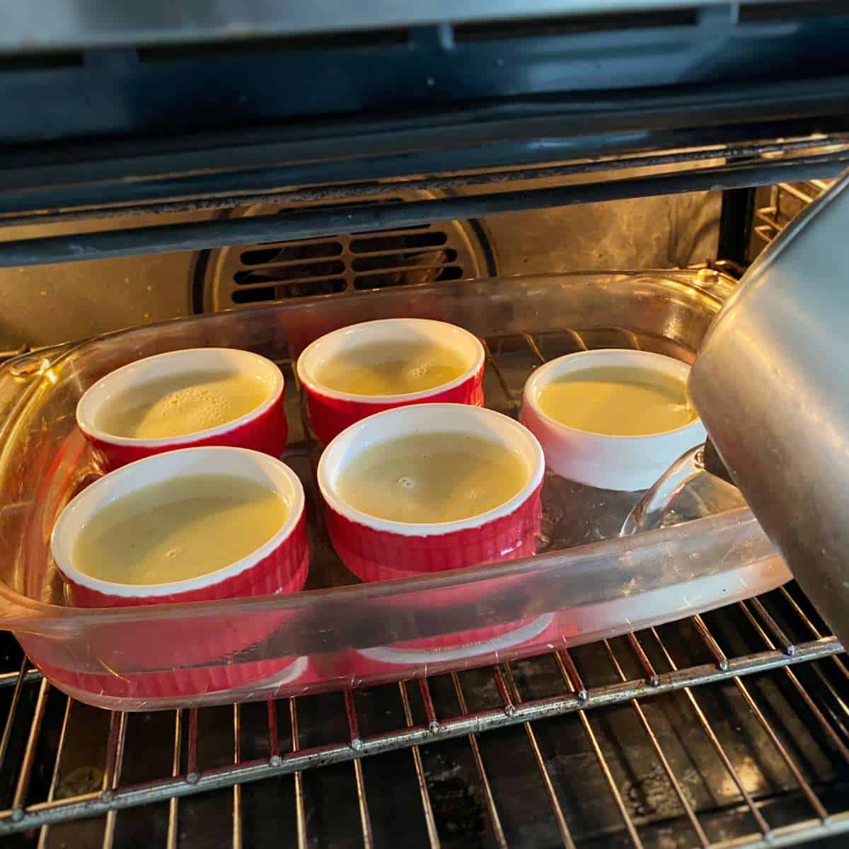 Five ramikins of creme brulee in the oven