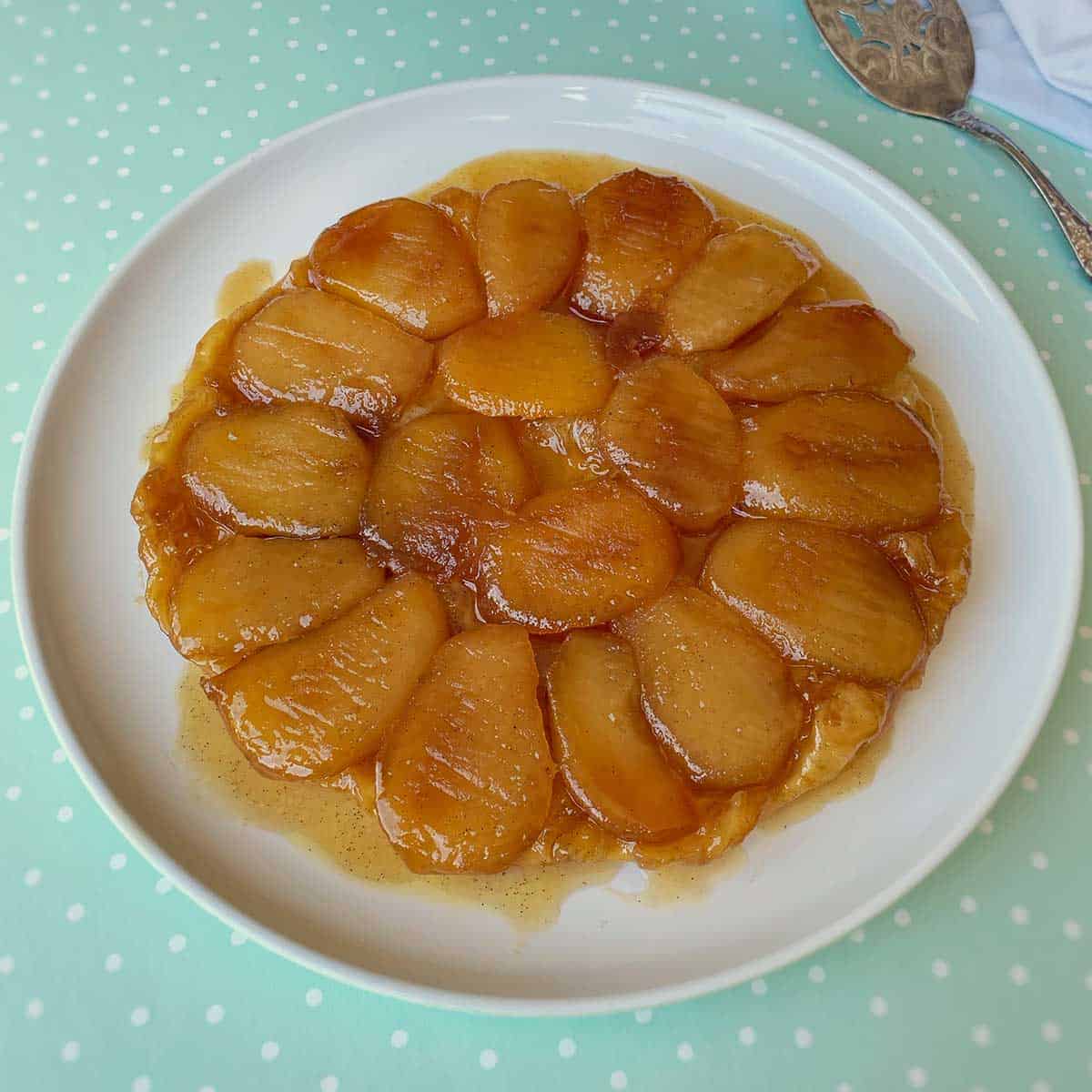 A cooked Tarte Tartin on a white plate.