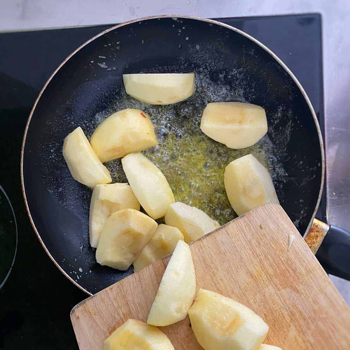 Apples caramelising in a frying pan.