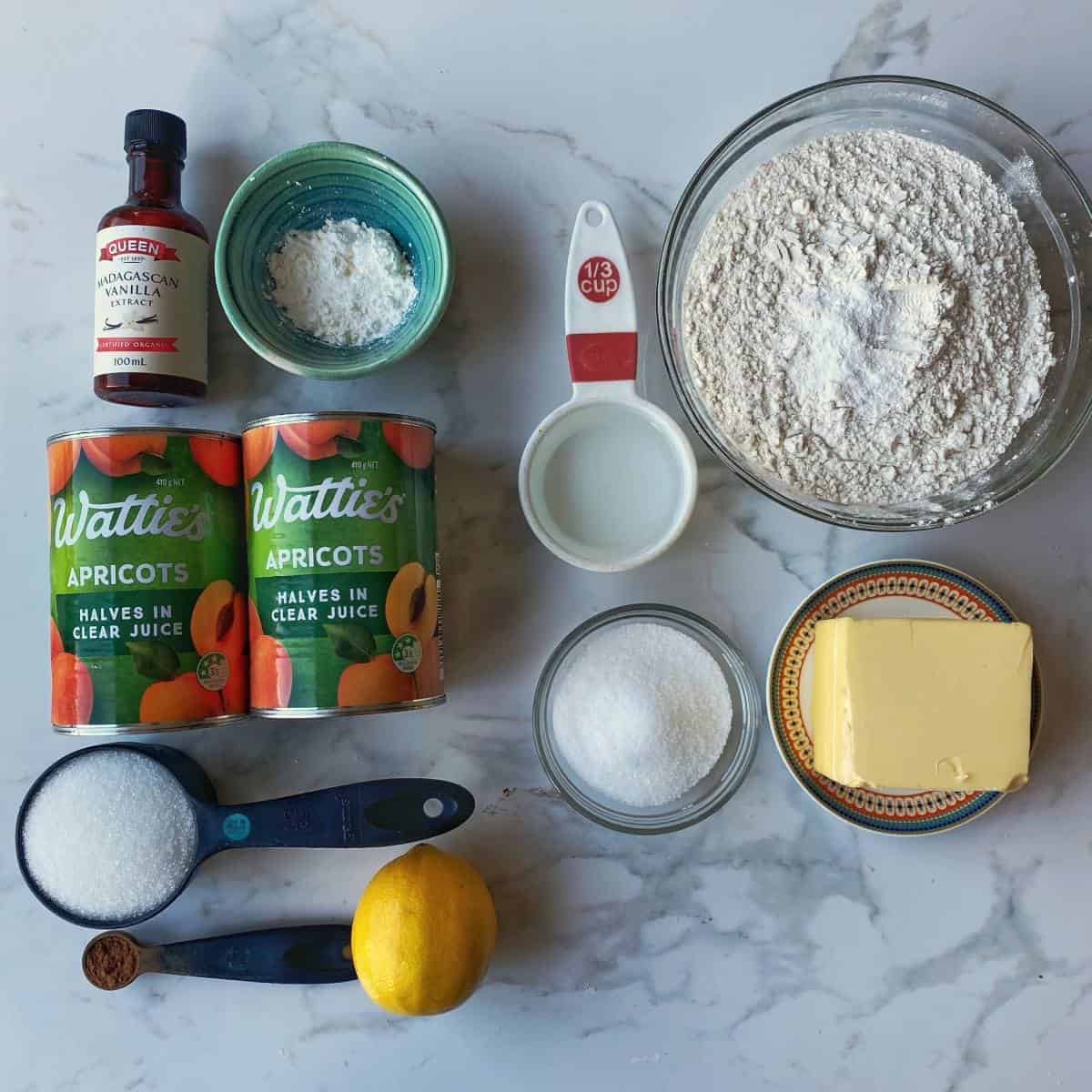 The ingredients for apricot short crust pie on a marble bench