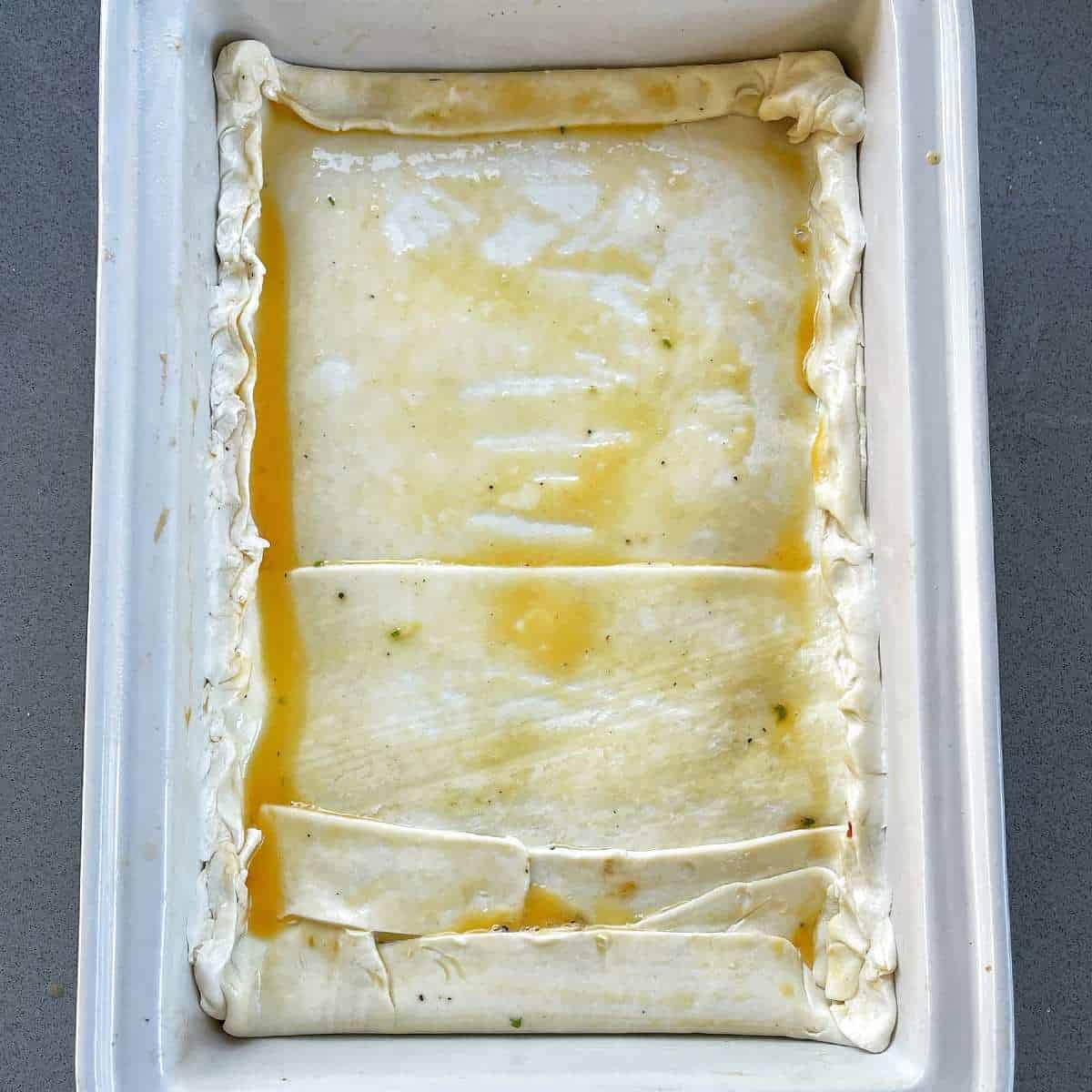 Uncooked bacon and egg pie in oven proof dish