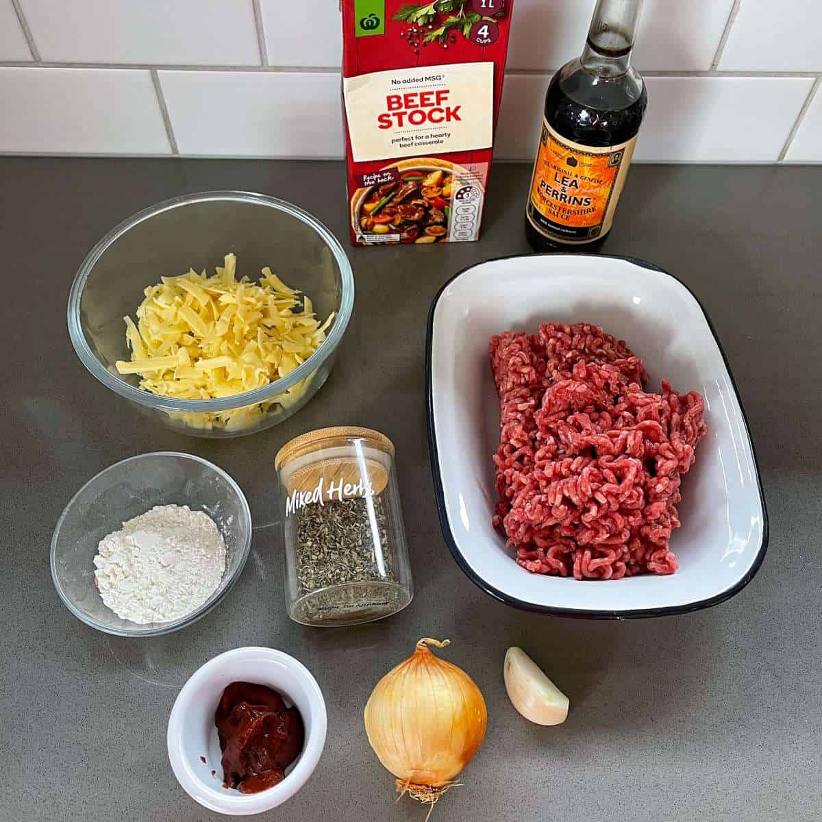 The ingredients for a mince and cheese pie sitting on a grey bench