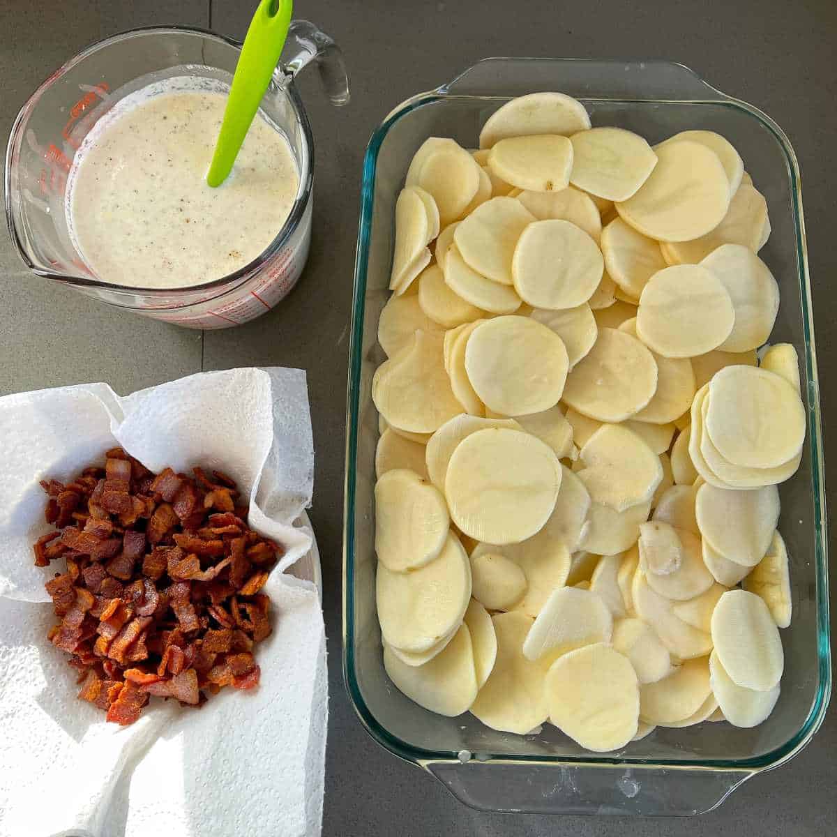 Cooked bacon pieces, uncooked sliced potatoes and the creamy, cheesy sauce for bacon and potato bake