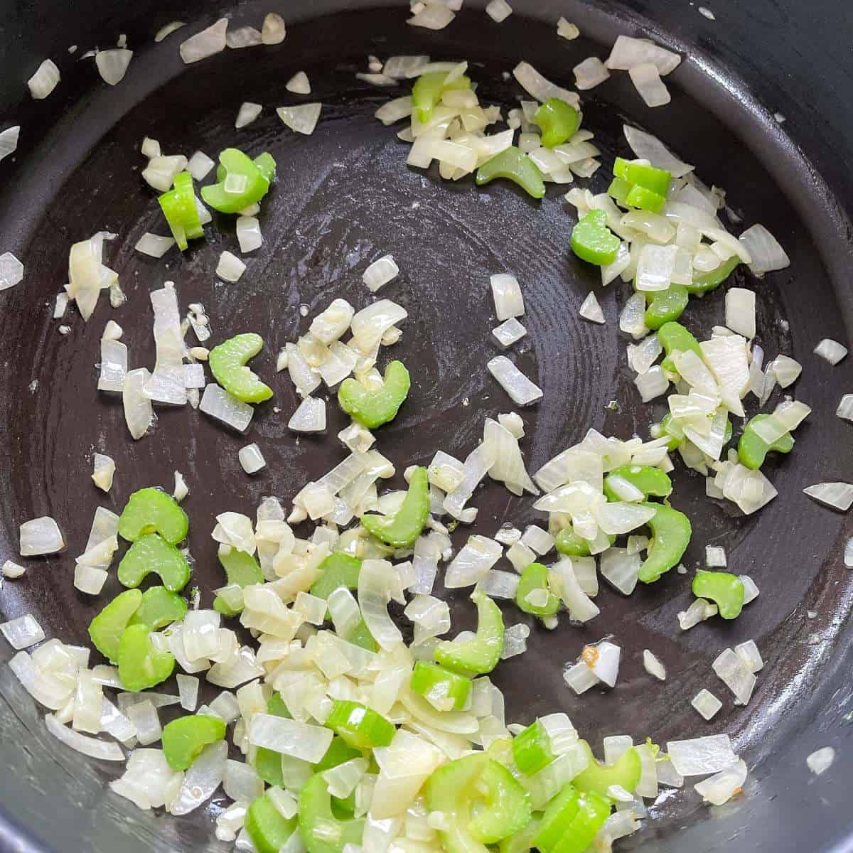 Chopped onions, garlic and celery frying in a frypan
