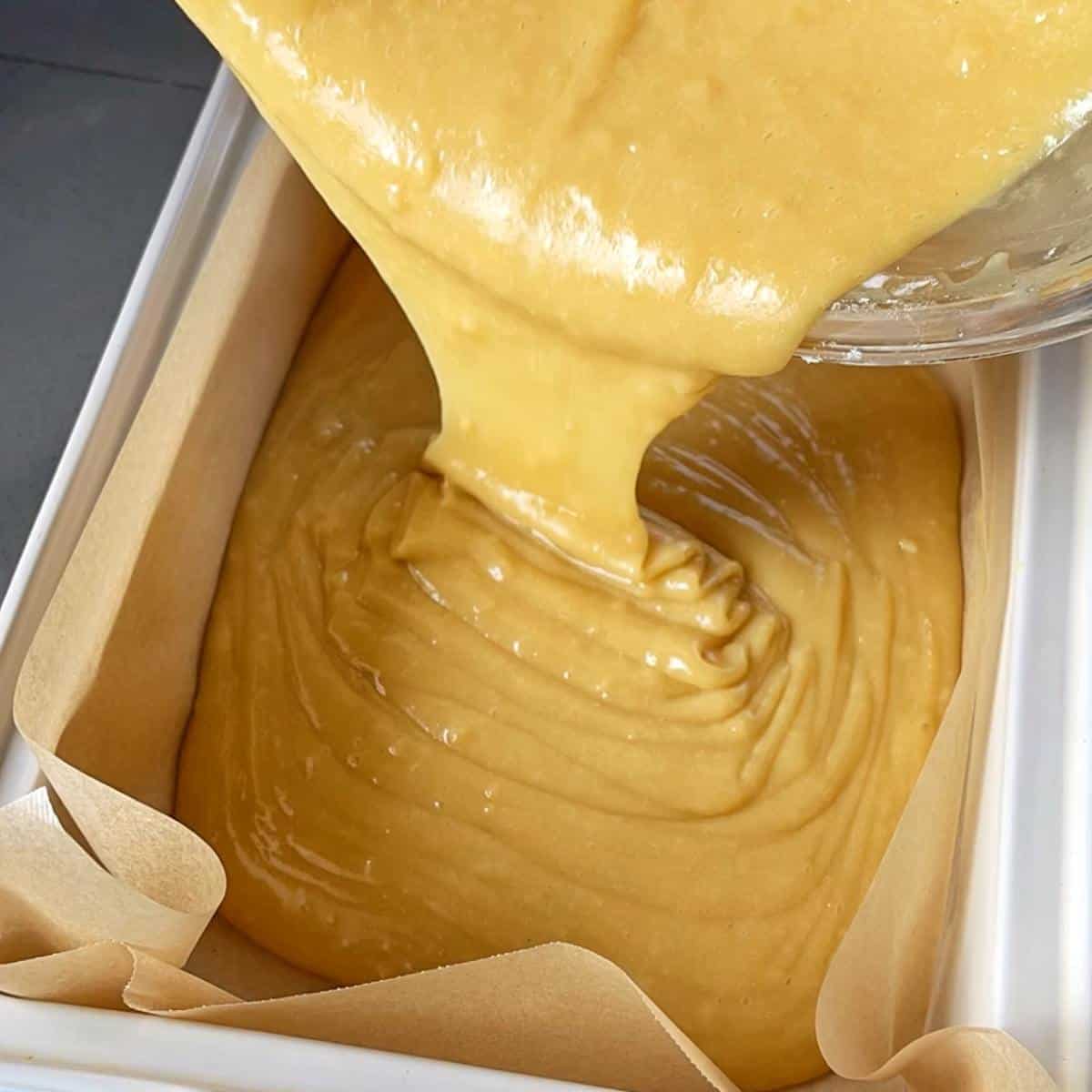 White Chocolate Mud Cake batter being poured into oven proof cake dish