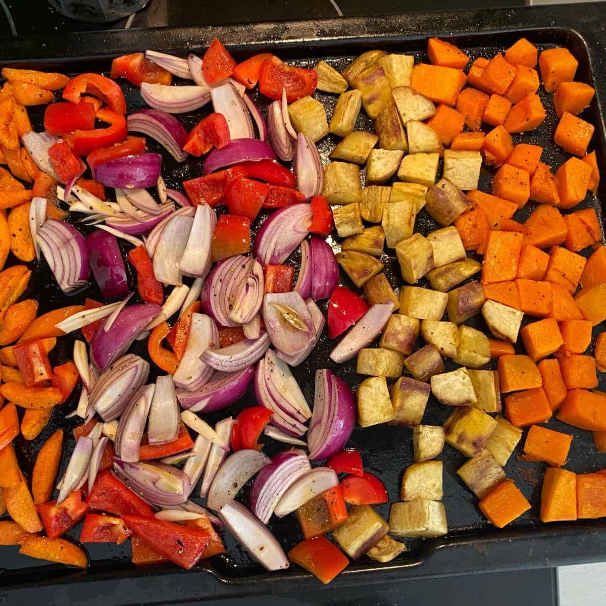 Cut roasted vegetables for the winter roast vegetable salad on a roasting dih