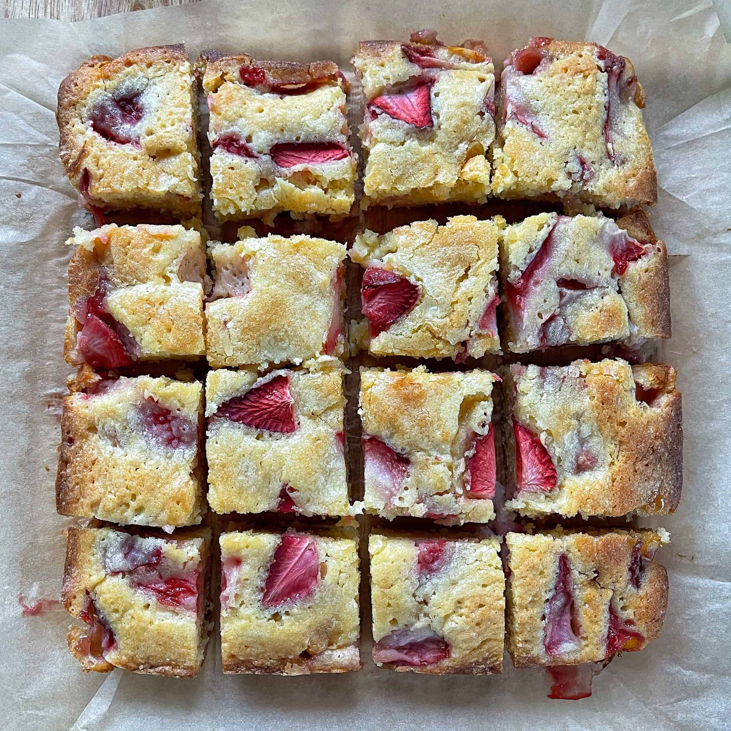 Cooked, sliced White Chocolate and Strawberry Blondie on a chopping board.