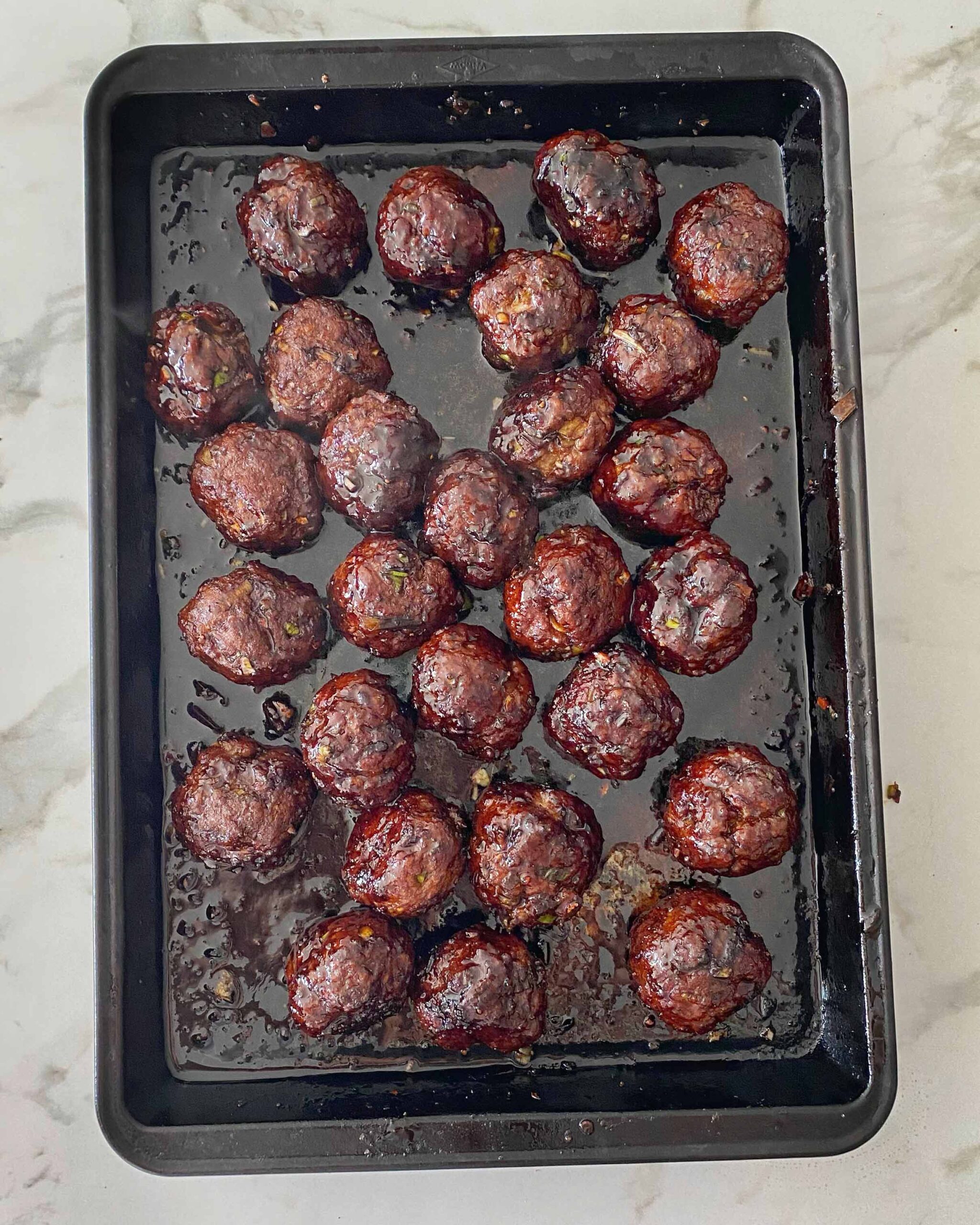 Baked meatballs on a baking tray.