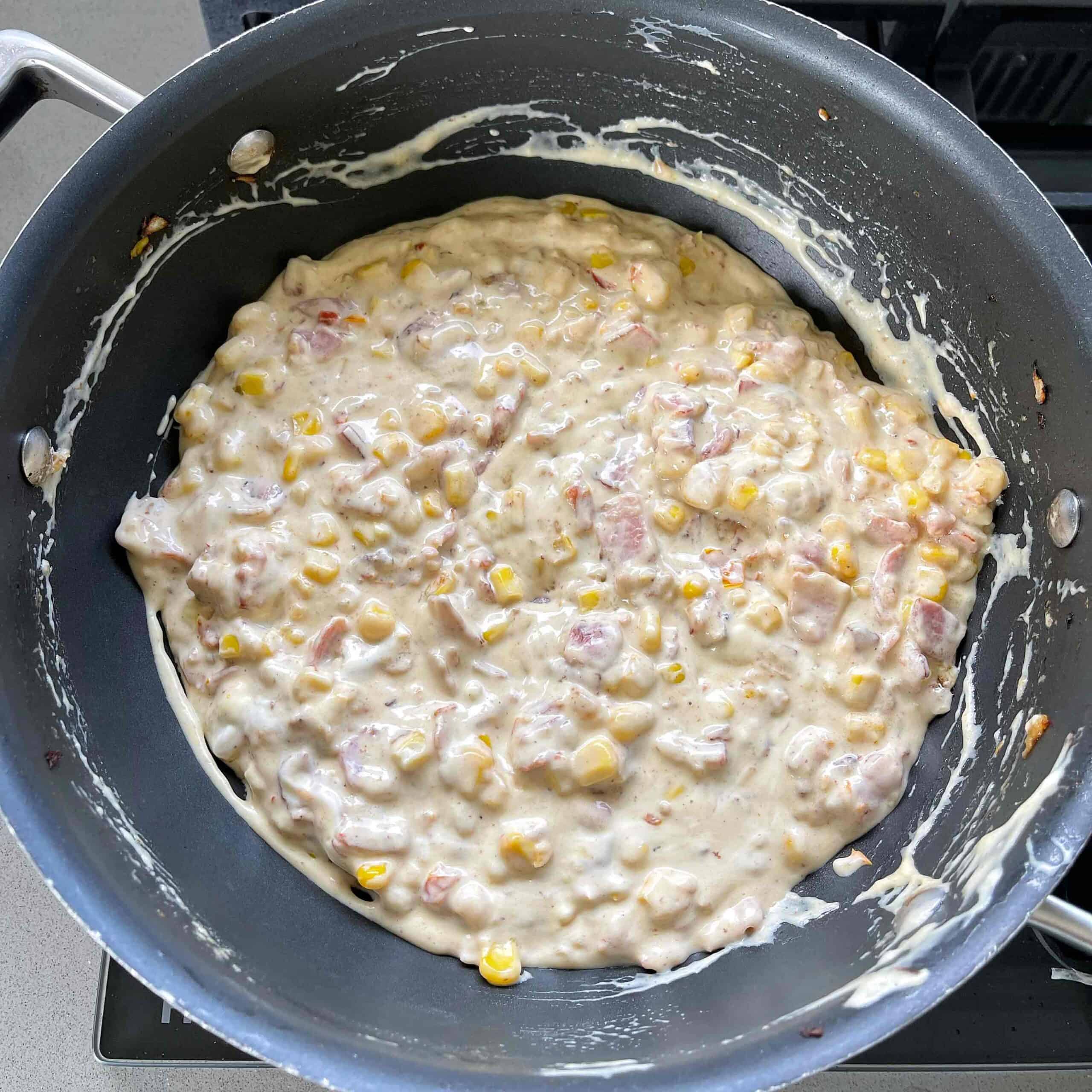 Bacon and corn dip in a frying pan.