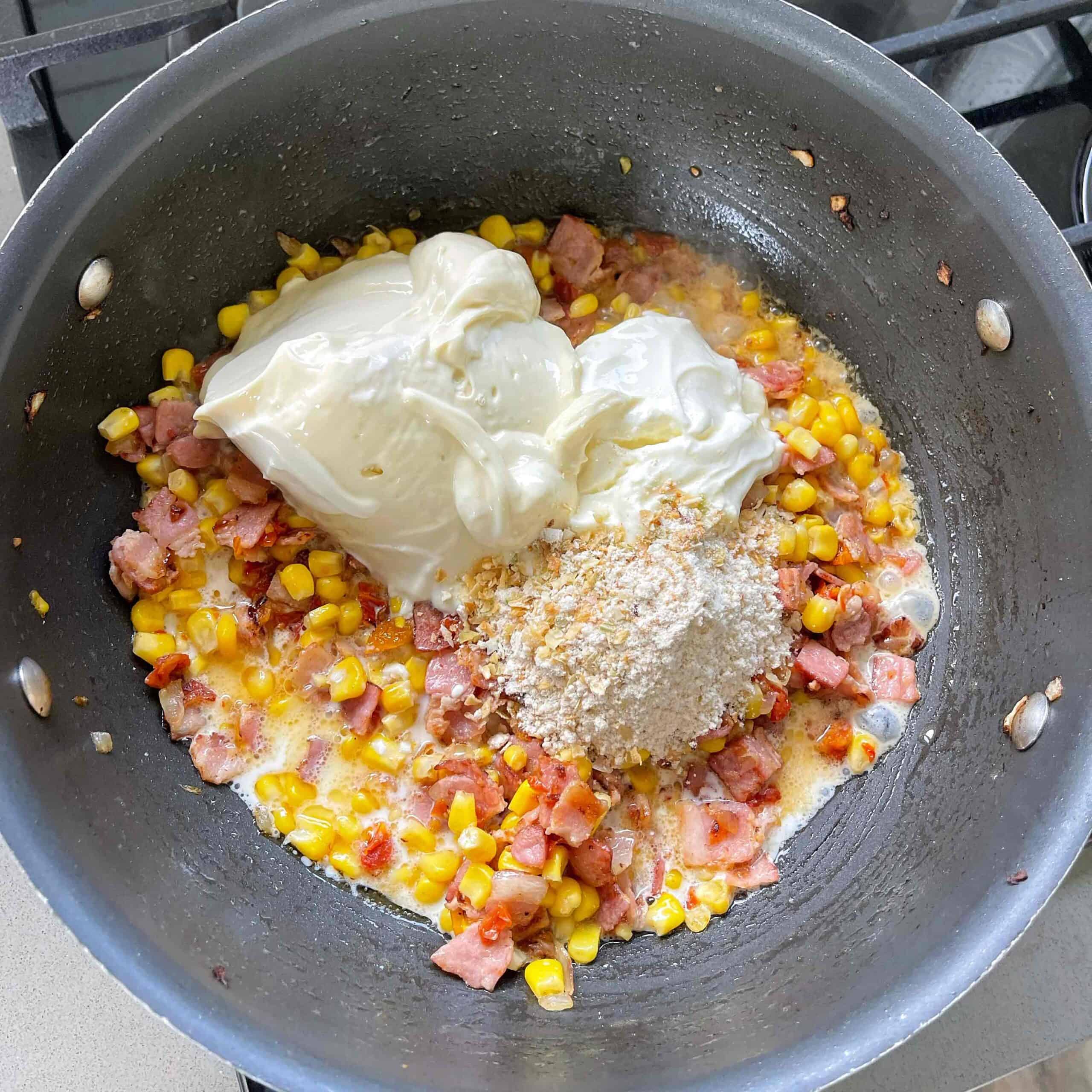 Bacon, corn and sour cream in a large frying pan.