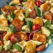Haloumi and avocado salad served in a light blue oval dish.