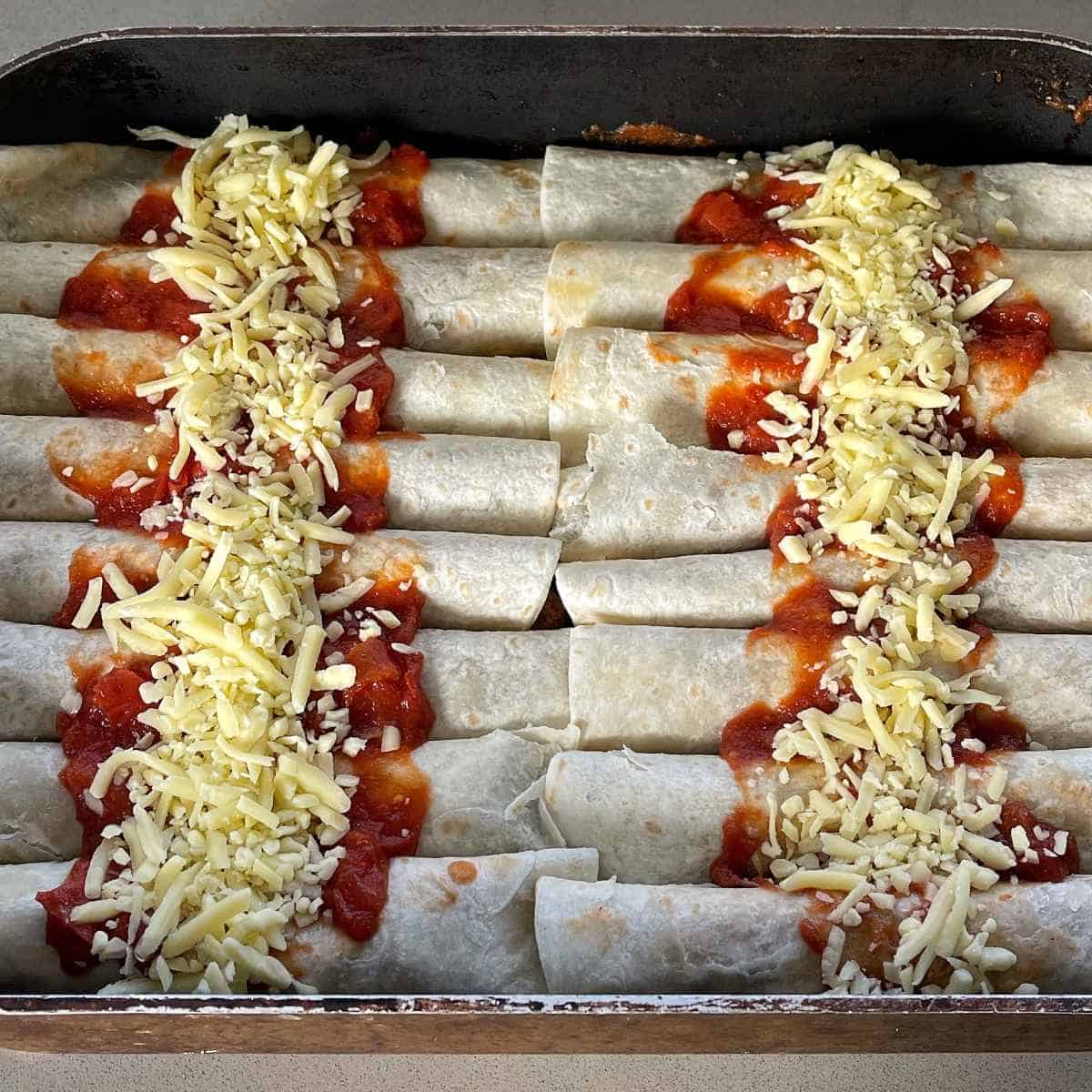 Beef enchiladas being prepared in a large tray