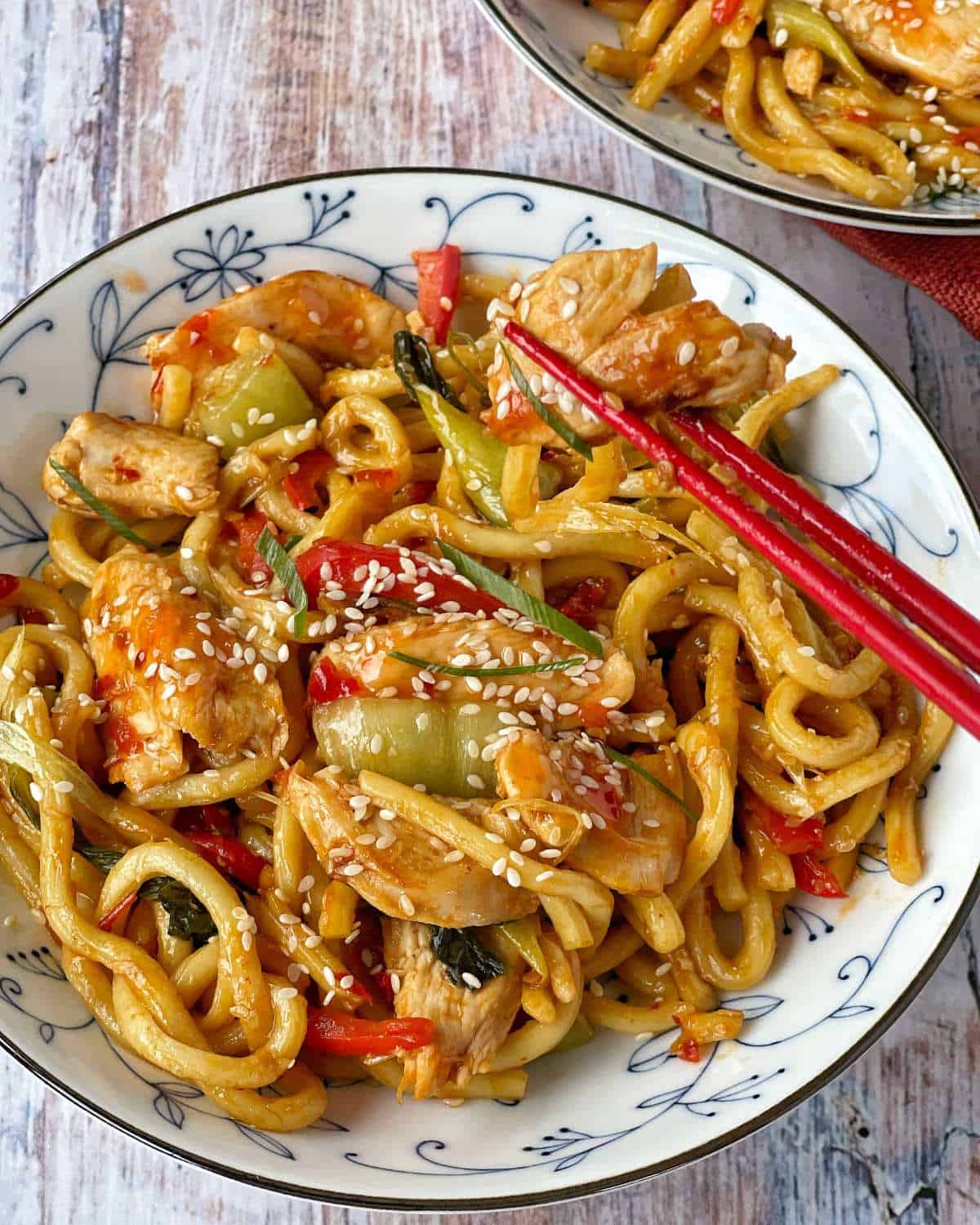 Sweet Chilli Chicken Noodles served in a small white bowl with chopsticks to the side
