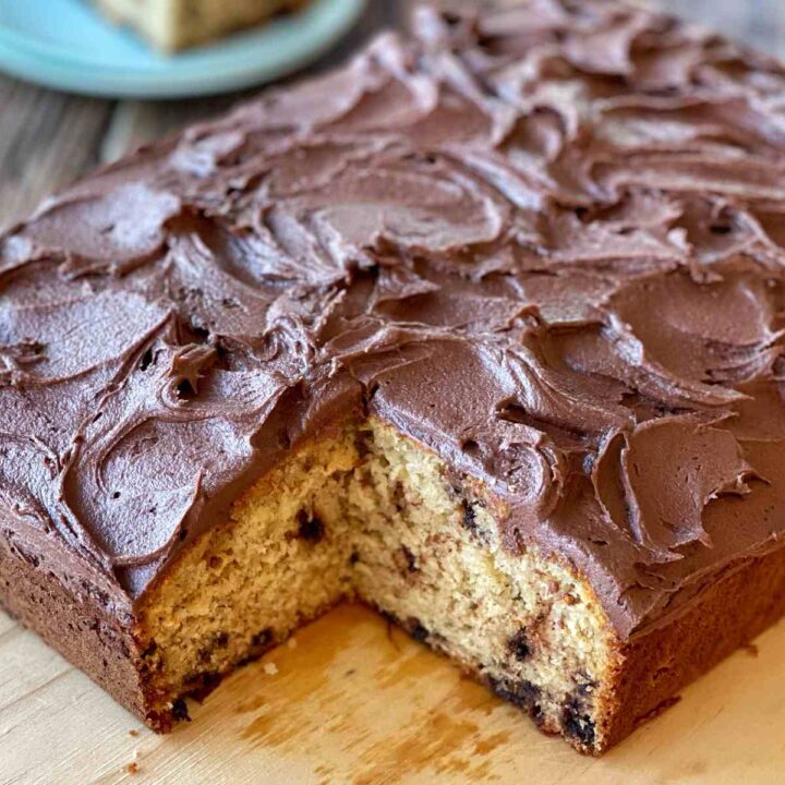A close up of a banana cake with the corner piece cut out.