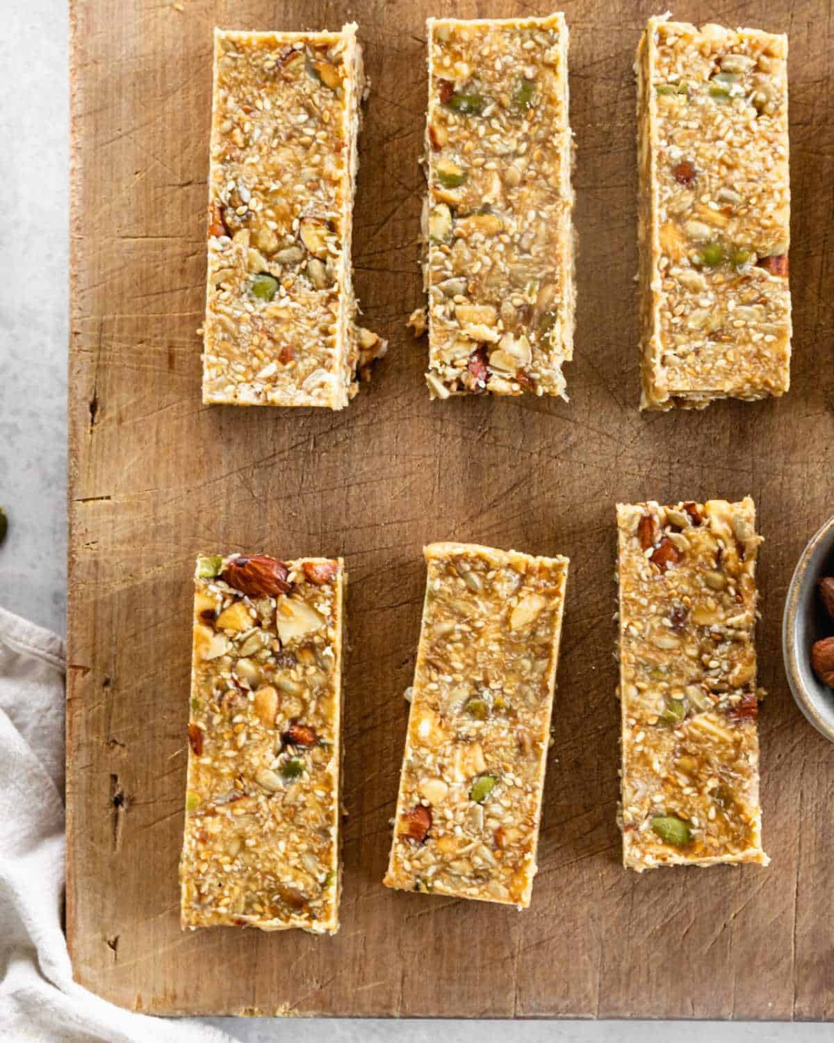 6 Nuts and seeds muesli bars on a wooden chopping board.