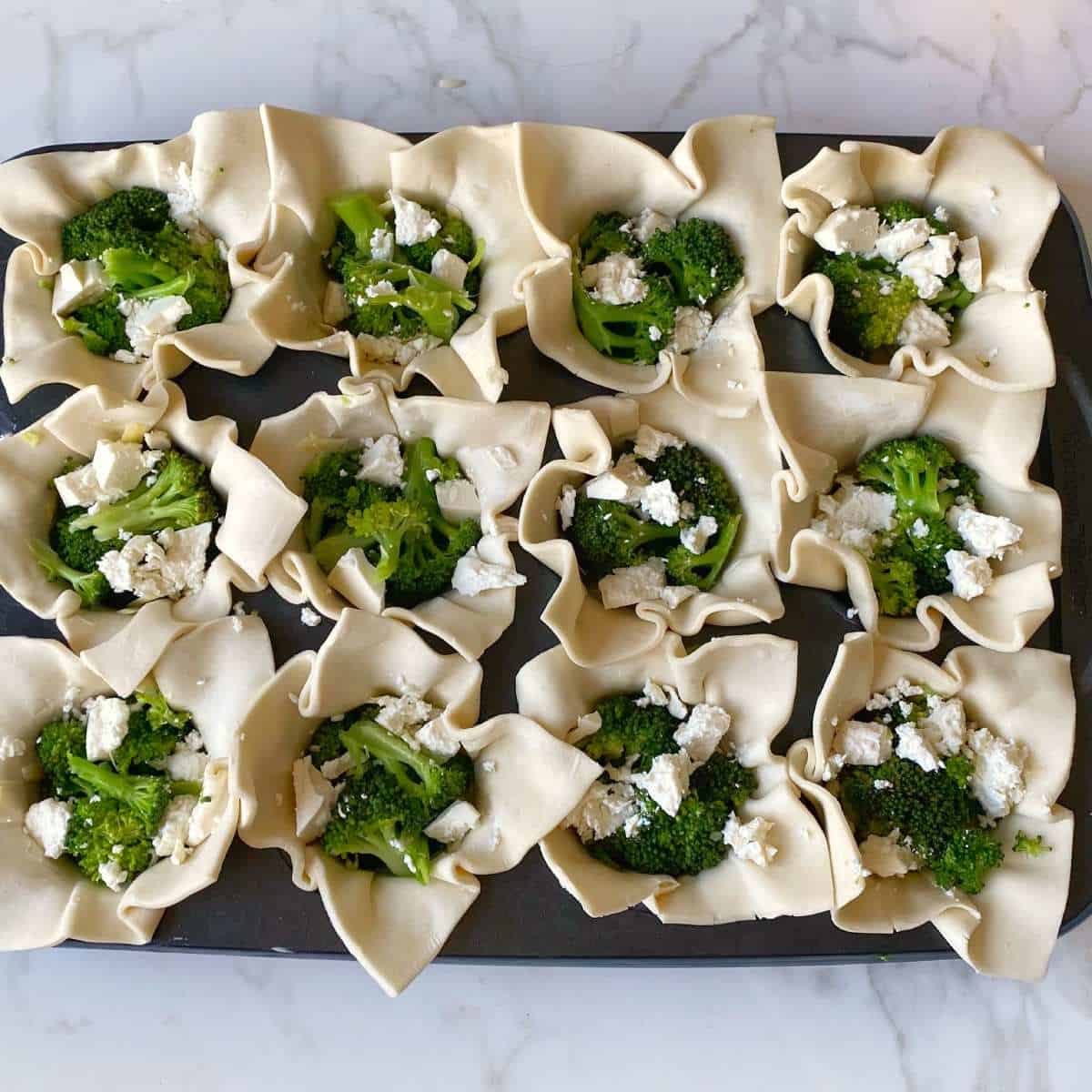 Broccoli and feta inside the individual pastry sheets for Broccoli and Feta Tarts