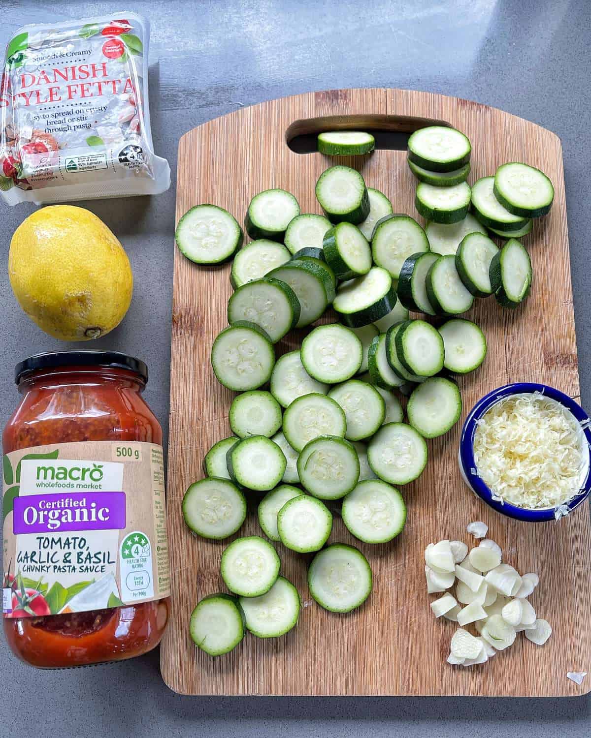 The ingredients for Zucchini and Tortellini Pasta on a wooden chopping board.