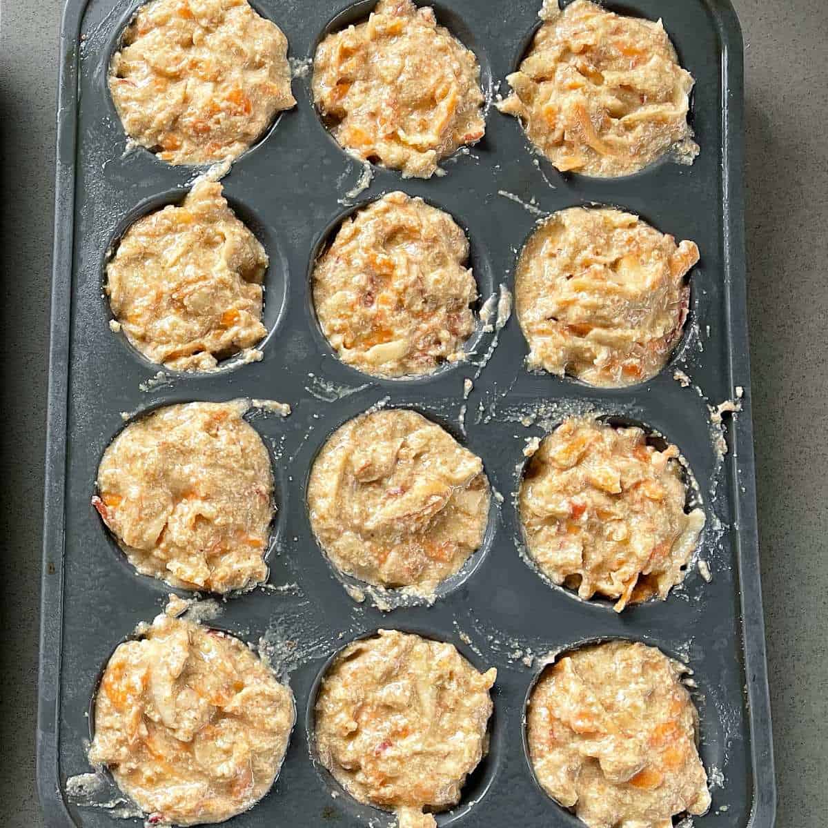 Uncooked ABC Muffins in a muffin tray.