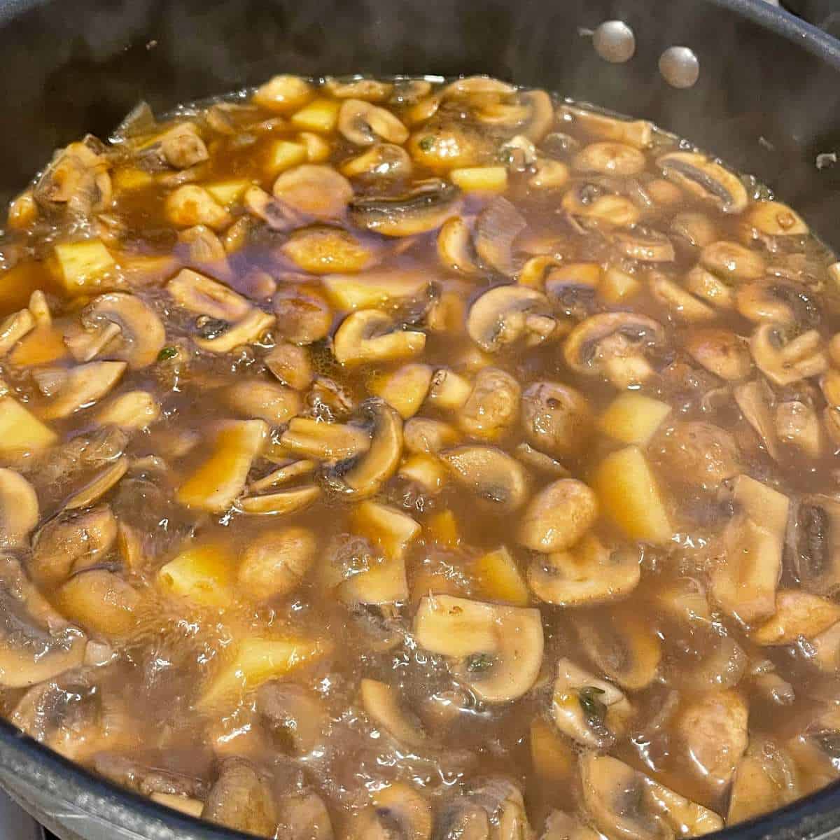 Simmering Creamy Mushroom Soup before it has been blended smooth in a medium frypan.