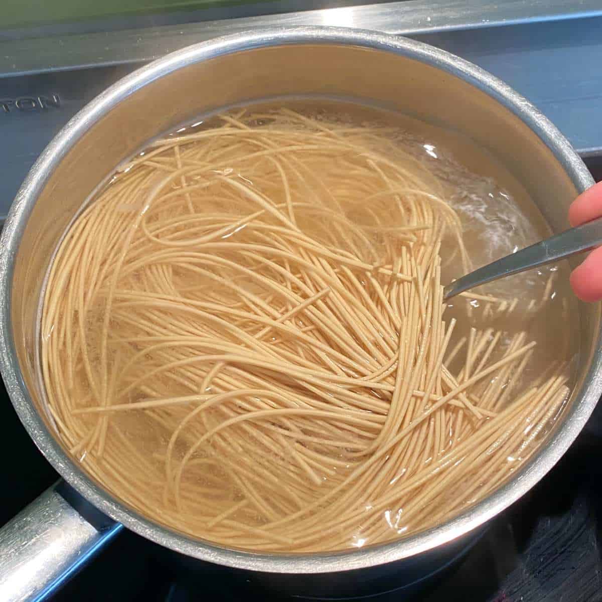 Ramen noodles cooking in a large pot of boiling water.