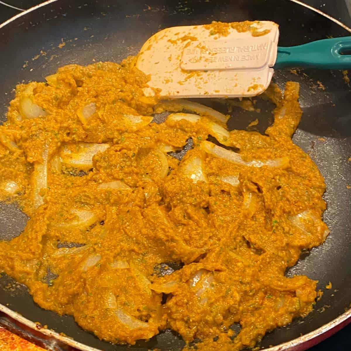 The spice mix and onion gently frying in a fry pan for the paneer curry
