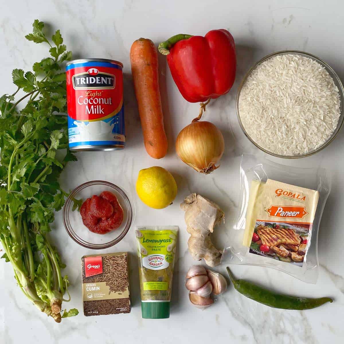 The ingredients for paneer curry on a marble bench top