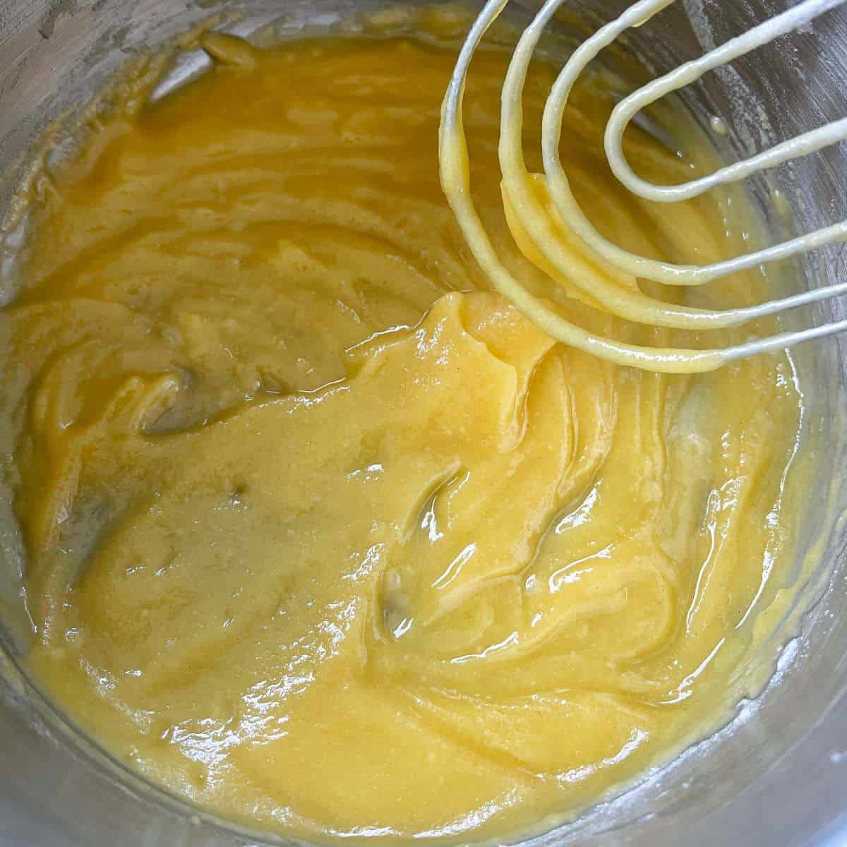 Melted butter and flour being combined over a low heat in a small pot.