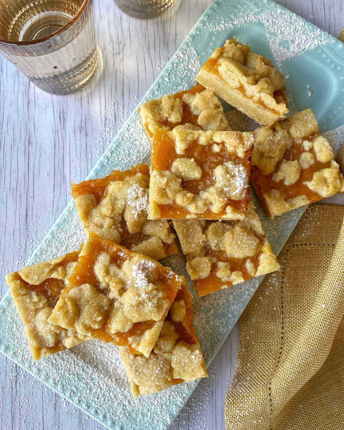 Baked Apricot Slice cut into pieces with a dusting of icing sugar.