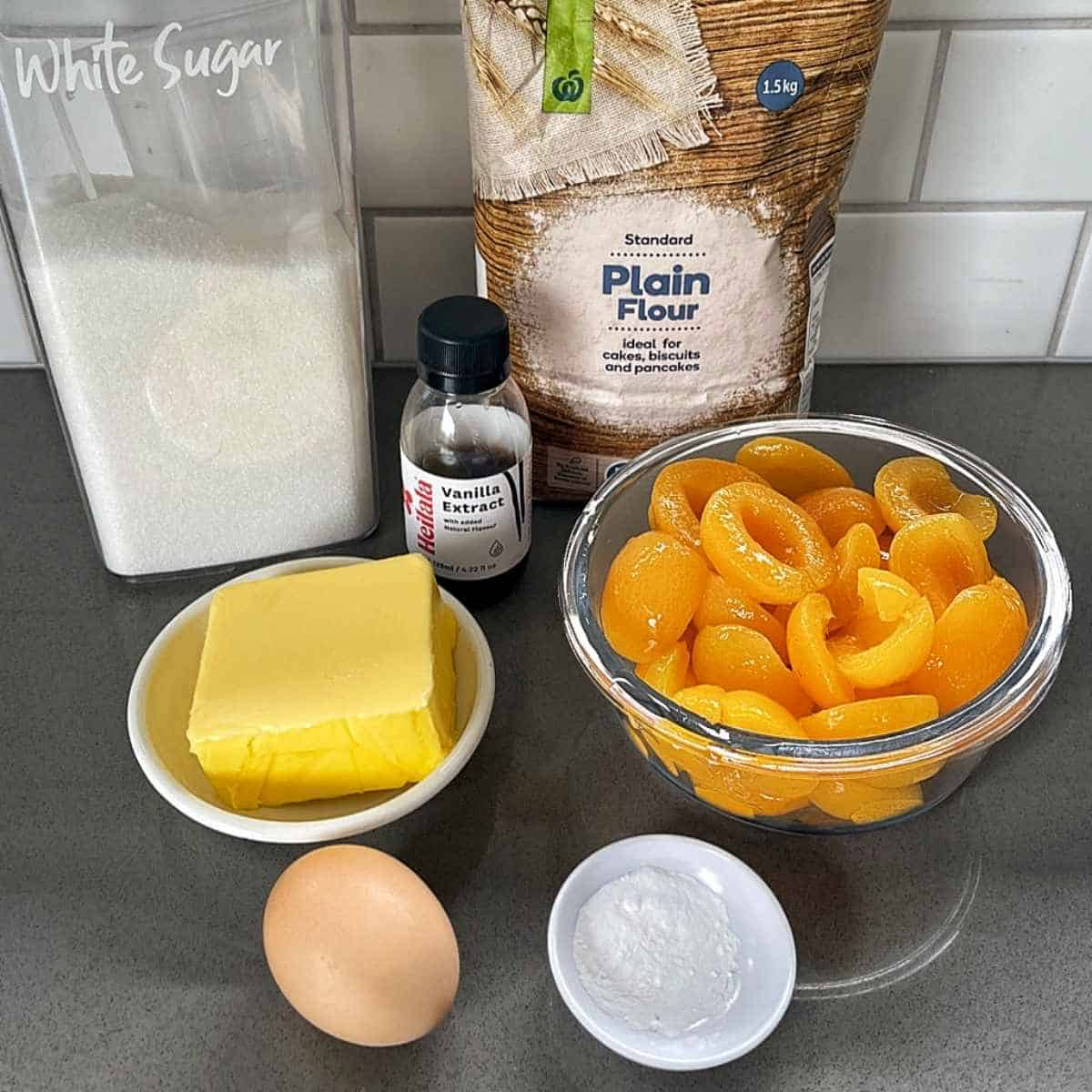 The ingredients for baked apricot slice on a grey bench top.