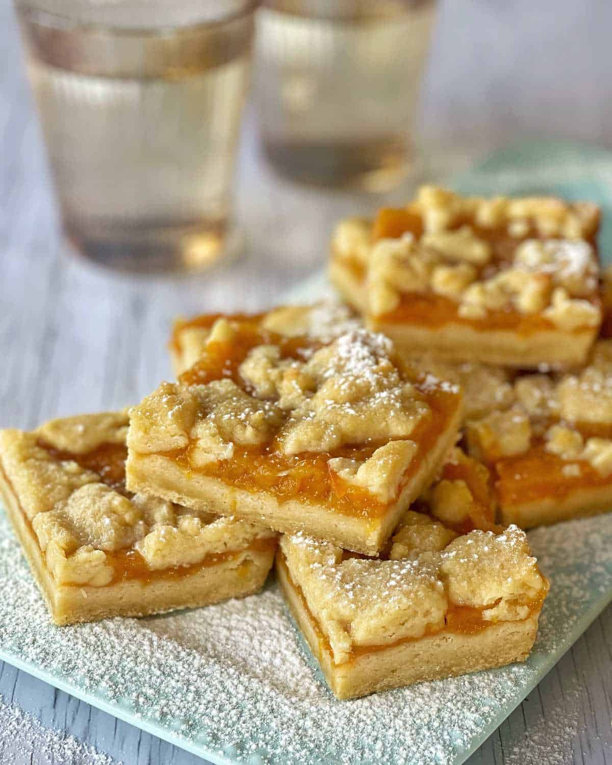 Baked Apricot Slice cut into pieces with a dusting of icing sugar.