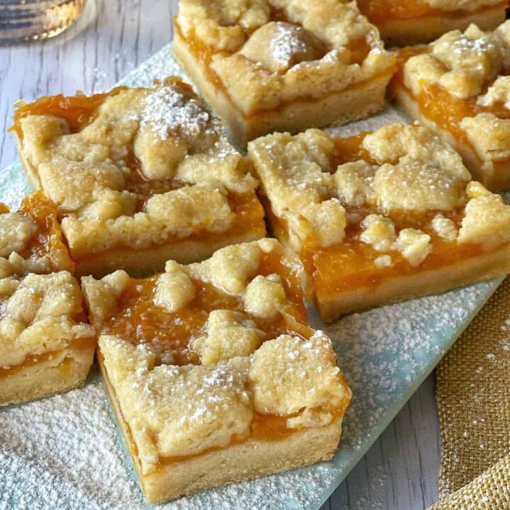 Baked Apricot Slice cut into pieces with a dusting of icing sugar.
