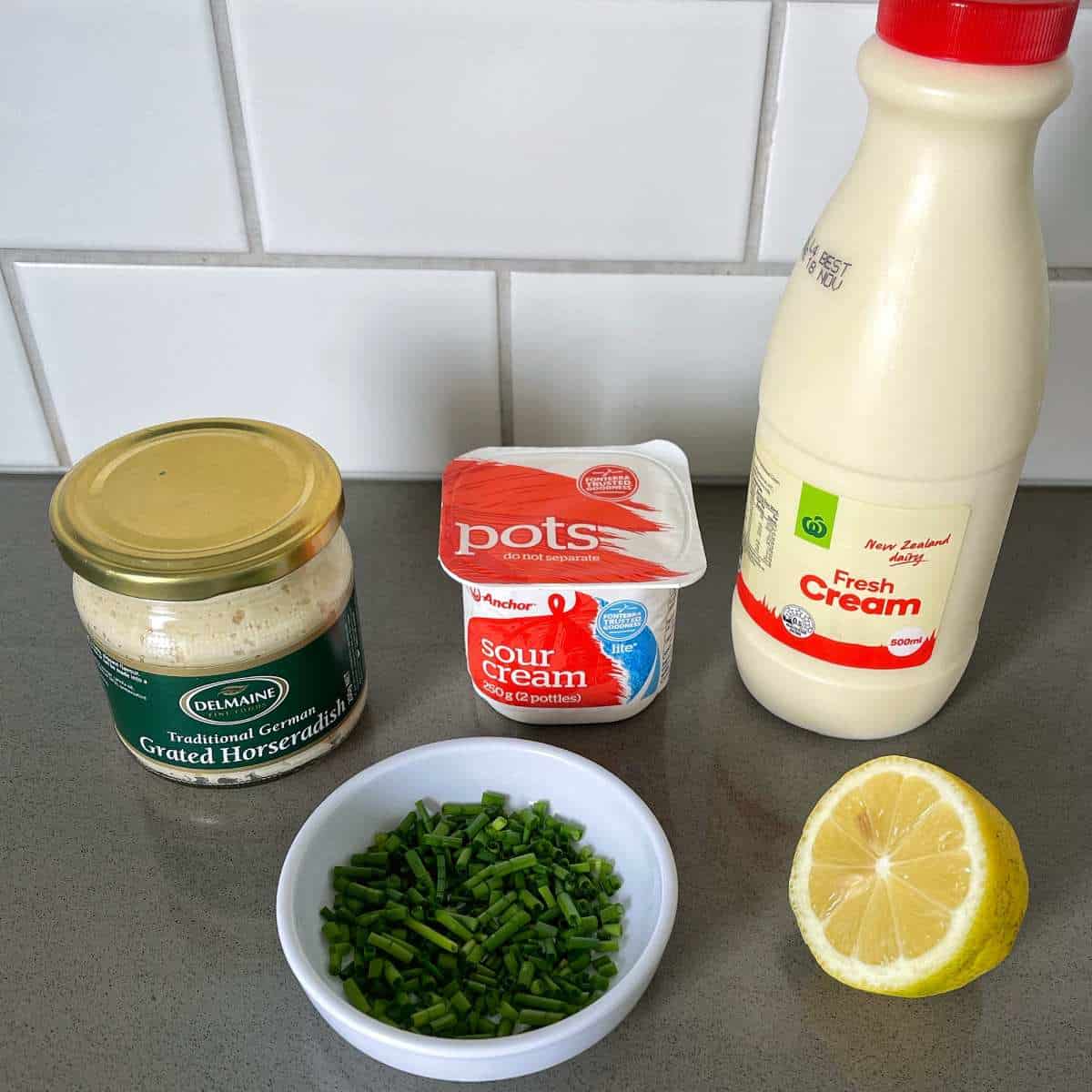 The ingredients to make creamed horseradish on a grey bench top