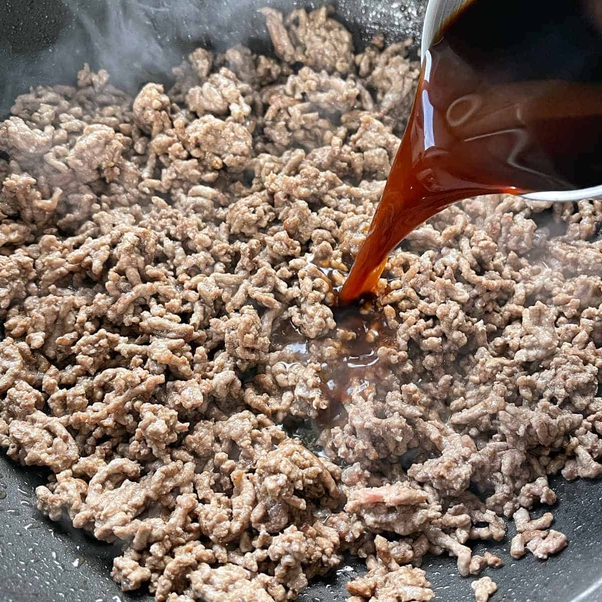 The stock being added to the mince for Big Mac Pizzas.