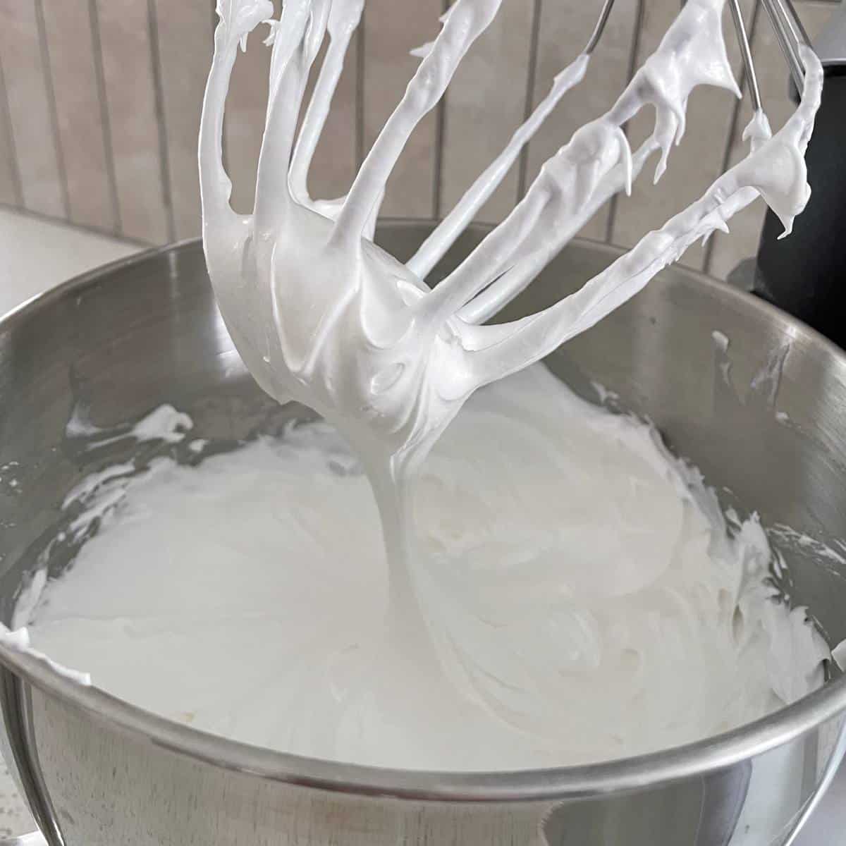Whisked egg whites and sugar to make meringue in a mixing bowl.