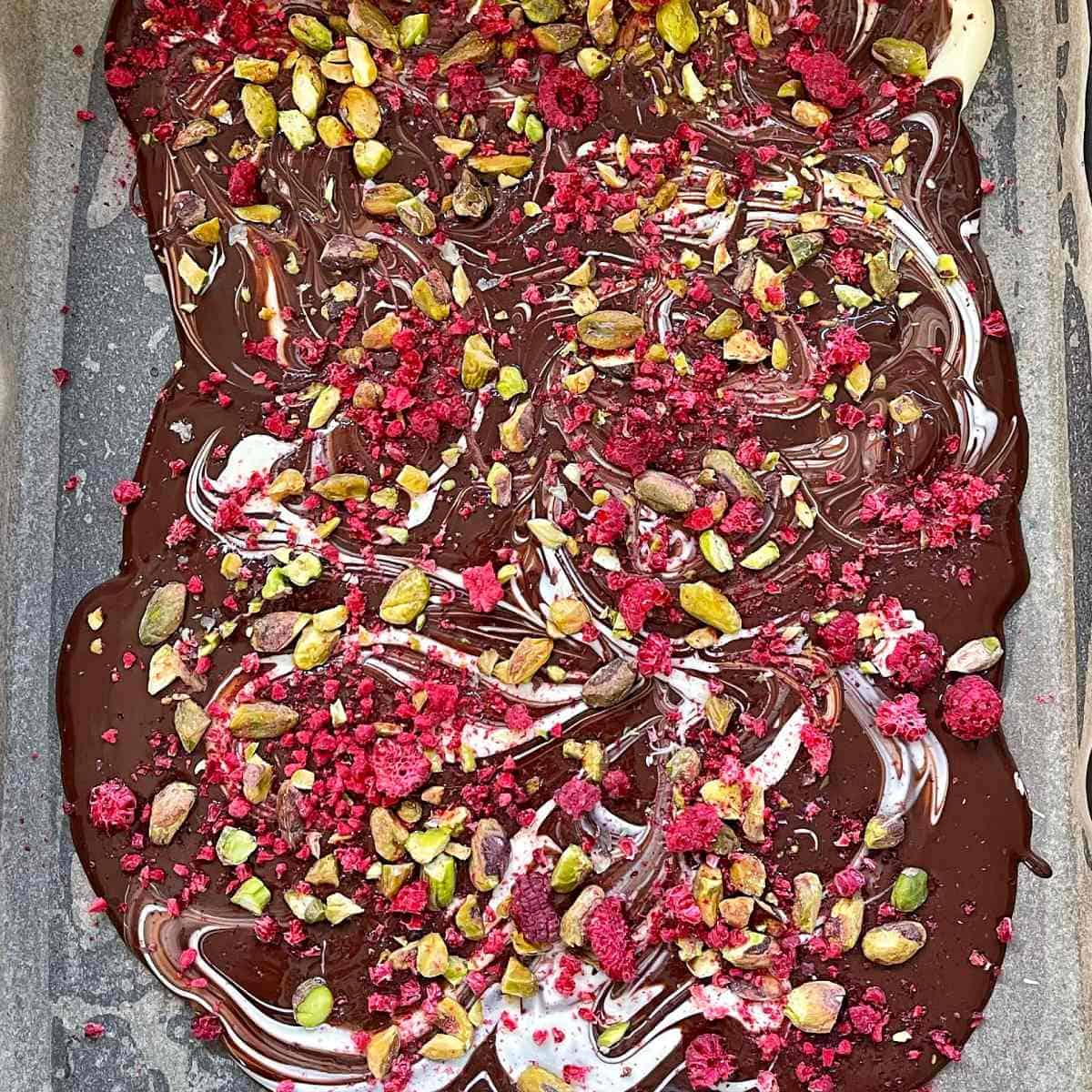Chocolate bark on a lined baking tray ready to set.