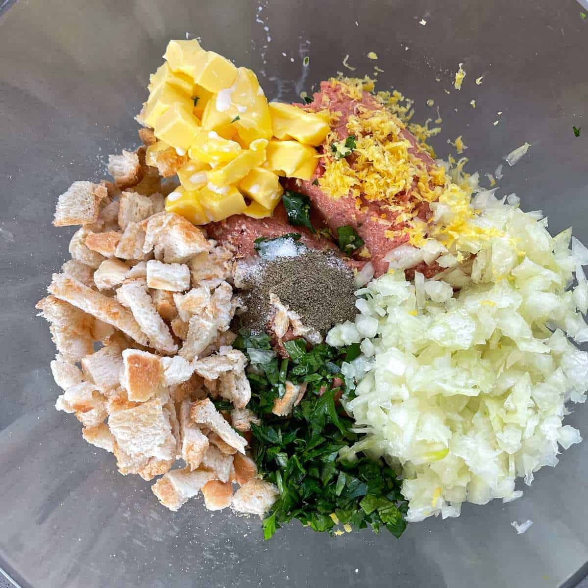 All of the chopped ingredients for the stuffing in a glass bowl.