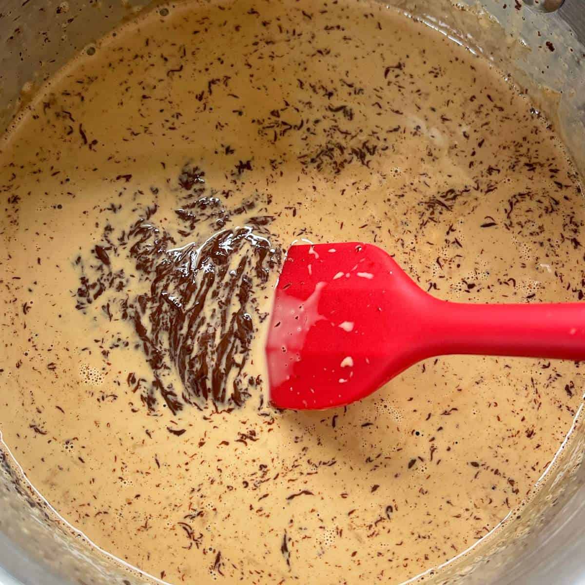 Heated cream with coffee and chocolate been gently melted through for Coffee Chocolate Parfaits.